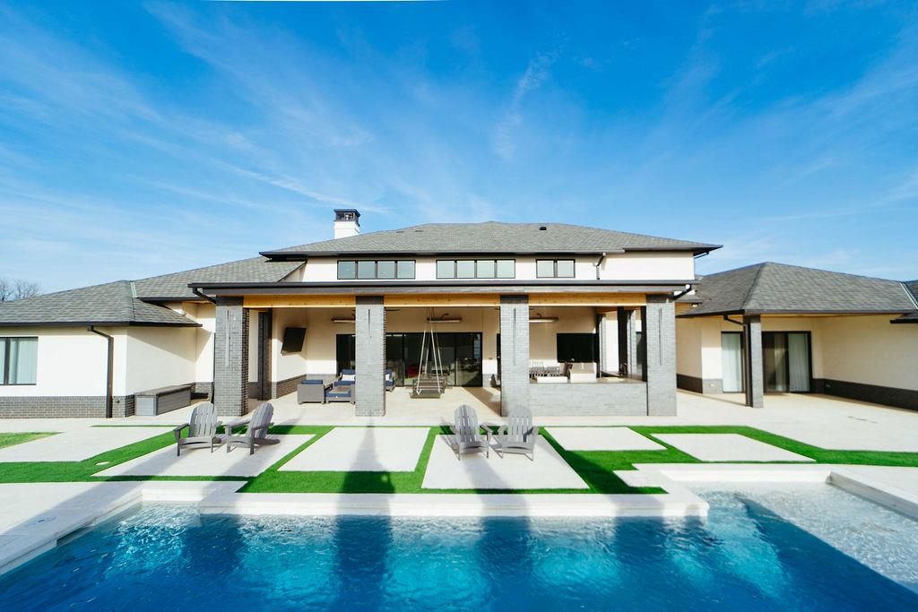 Tucked away in the infamous Rivendell neighborhood in south Oklahoma City, this one-of-a-kind home offers modern elegance, and that break from reality you've been longing for. Thoughtfully designed with peace and relaxation in mind. Brought to life by Jim Bowers, with his unparalleled craftsmanship. Sitting on just over a half an acre, this 6,978 sq.ft. home offers that vacation style energy you didn't know could last forever. From the moment you wake up with your morning coffee or tea on this remarkable covered back patio, overlooking the designer tiled pool and hot tub with the delightful waterfall ambiance. To evenings in your chef's kitchen with oversized island and seating, separate prep kitchen, sipping on delicious cocktails prepared right off the kitchen at your glamorous wet bar. Notable features include high efficiency Geothermal energy, stunning prayer room, exercise room, safe room, oversized 4 car garage with abundant storage, up and downstairs laundry, cozy reading nook and spacious living room on second floor with mini fridge, ice-maker and sink with entertaining in mind. Backyard oasis also includes remote-controlled screened in porch and built-in heaters, for year round enjoyment, as well as a sleek gas fire pit. Summer grilling in your outdoor kitchen paired well with the raised vegetable garden beds for garnish. Experience this masterpiece that is both modern and timeless. Your endless vacation awaits you!