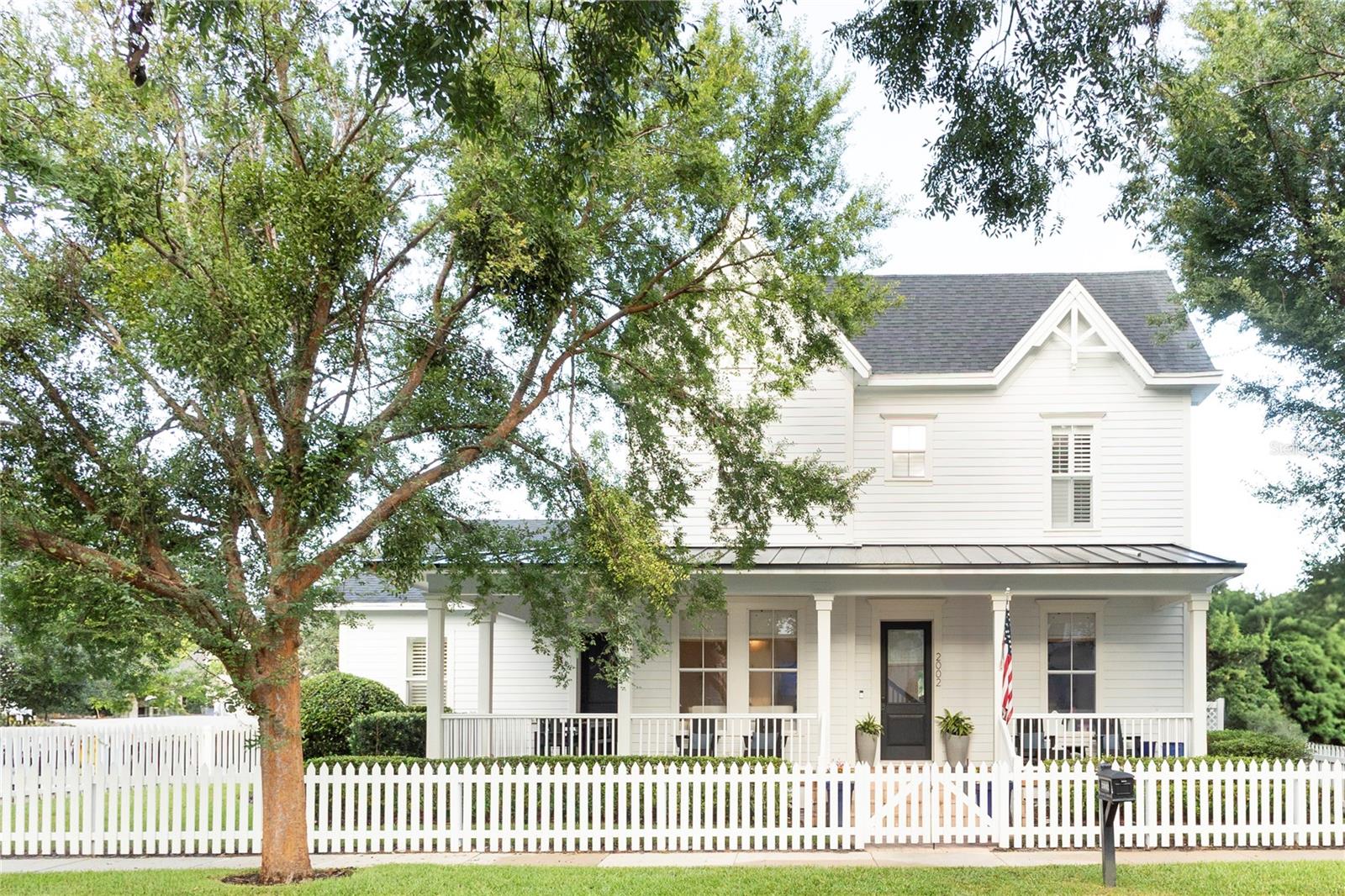 This spectacular 4-bedroom, 3.5 bath custom home, dramatically expanded and fully redesigned in 2020, is a rare offering. Set on a corner lot just one block from a park, this Victorian farmhouse-with its wraparound brick-paved porch and classic white picket fence-embodies the very best of Baldwin Park living. Owned by an interior designer, the home showcases exceptional craftsmanship and refined finishes throughout, including Lutron smart lighting, level-4 drywall, fully trimmed windows with woven shades, new 8' doors, and custom Masterpiece closet systems. The downstairs primary suite is a true retreat, featuring vaulted ceilings, dual walk-in closets, and a luxurious marble bath with a freestanding soaking tub and an oversized walk-in shower with three shower heads.At the heart of the home, the kitchen is designed for both everyday living and entertaining, offering an 11-foot island, built-in ovens, natural quartzite countertops, an oversized pantry, and two additional deep-storage closets. The adjoining family room and casual dining area overlook the heated saltwater pool and spa, finished with Artistic paver decking-the same used at the Ritz-Carlton Grande Lakes. Mature landscaping provides exceptional privacy and lush views.One of the home's standout features is the oversized mudroom and laundry room, complete with custom cabinetry, backpack and shoe cubbies, and natural quartzite countertops, seamlessly connecting to the spacious two-car garage. The extended driveway can fit up to 4 cars and leaves plenty of room for basketball. A formal dining or sitting room and a private office complete the first floor.Upstairs, a second primary suite offers dual sinks, a soaking tub, separate shower, and walk-in closet. The upstairs also features a spacious bonus space along with a convenient second laundry closet. Two additional upstairs bedrooms share an expanded, beautifully appointed bath.Throughout the home, abundant storage and thoughtfully designed spaces enhance everyday living. 2002 Shaw Lane is a truly exceptional home-where timeless architecture meets modern luxury.