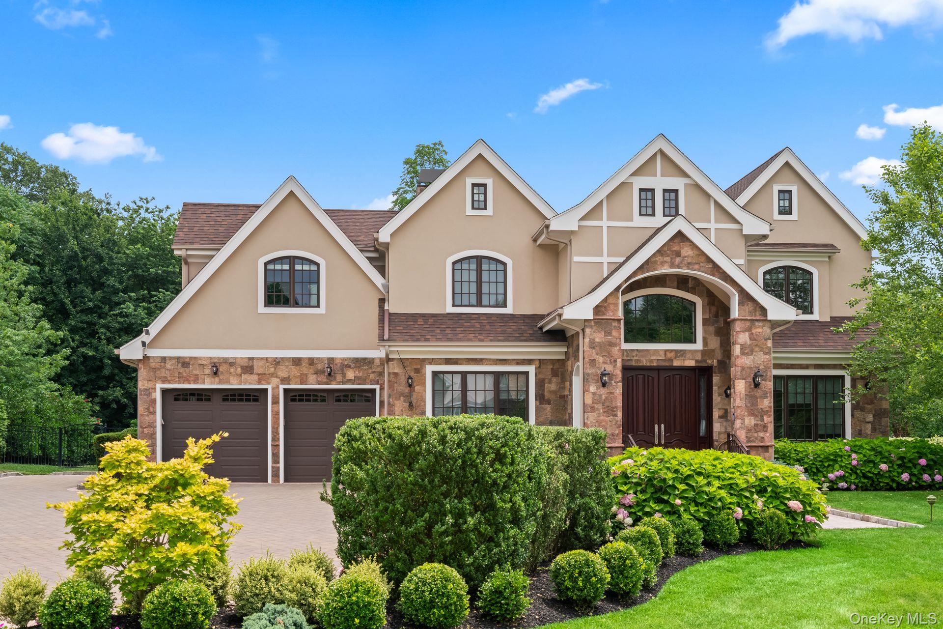 Welcome to 11 Buckingham Ct — an exceptional Colonial-style residence in the prestigious gated community of Stone Hill, Muttontown. This one-of-a-kind, custom-built young home offers approximately 5,500 sq. ft. of refined living space, seamlessly blending timeless architecture with modern luxury. The impressive entry sets the tone for this elegant yet inviting residence. Step inside through the grand mahogany double doors to a soaring two-story foyer with a graceful bridal staircase. The home’s elegance unfolds with imported granite floors, radiant heat throughout the main level, coffered ceilings, exquisite moldings, and finely crafted millwork. The impressive double-height living room is a showstopper, featuring a majestic fireplace, dazzling chandelier, and French doors that open to a serene patio. A true gourmet will fall in love with the chef’s kitchen, designed with custom artistic cabinetry, imported countertops, high-end appliances, a large center island, and abundant natural light. A rare second kitchen with extensive storage / sink / dishwasher adds to the home’s thoughtful design. For seamless entertaining, a sophisticated butler’s pantry connects the kitchen to the formal dining room. The first-floor grand primary suite is a retreat in itself, complete with a private sitting room/office, a lavish primary bath with dual facilities, and a separate laundry room. Also on the main level is a second ensuite bedroom—ideal for guests or in-law. An elevator services all levels, including the second floor, which is as functional as it is stunning. Here you’ll find four additional ensuite bedrooms, an office, a gym, a full bath, a second laundry room, and two spacious finished walk-in attics. The partially finished basement offers an incredible 3,000 sq. ft. of open space with soaring 10-foot ceilings and a walkout entrance—ready to be customized to your lifestyle. Outside, the park-like half-acre property blooms year-round with flowers and trees, providing a private, tranquil backdrop. The home is equipped with advanced features including 7-zone radiant and HVAC heating (with instant hot water), Marvin windows, an architectural roof, central vacuum, and a whole-house water filtration / water solften system—all ensuring comfort and efficiency. Stone Hill offers premier community amenities, including an indoor heated pool, tennis courts, gym and clubhouse, all within the award-winning Syosset School District. 11 Buckingham Ct isn’t just a home—it’s a statement of luxury living.