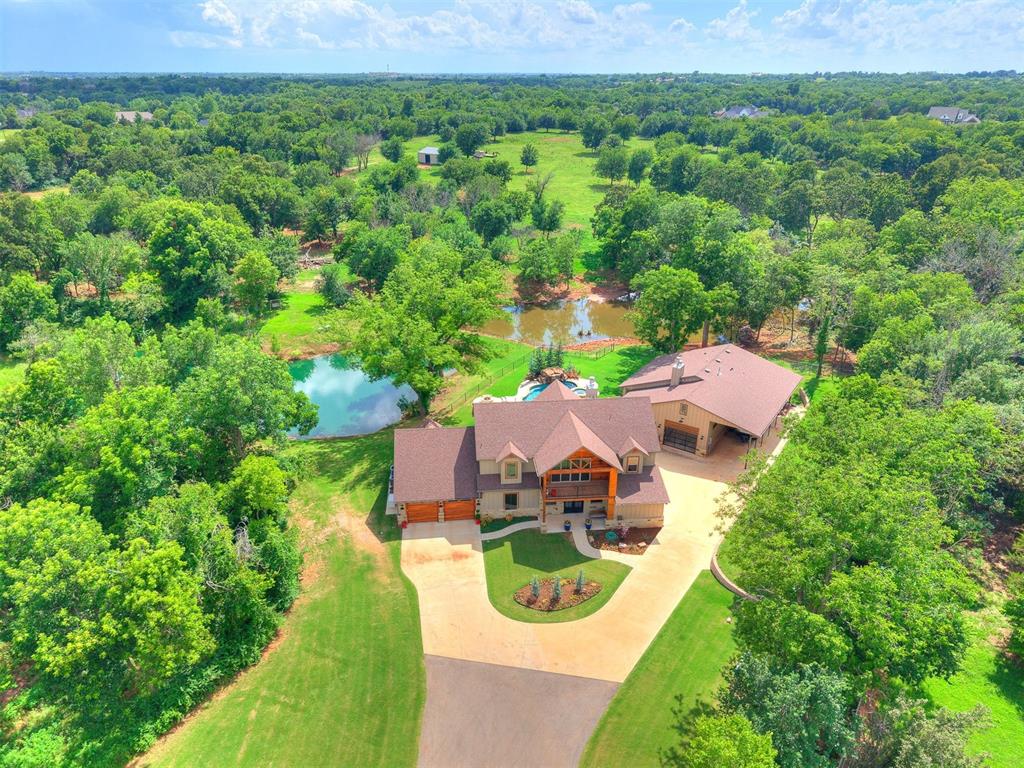 Once part of the historic Norman Golf Club, this extraordinary 25 acre property combines timeless natural beauty with thoughtfully designed luxury living. Rolling hills, serene ponds, & mature trees provide a breathtaking backdrop for both the main residence & secondary house, creating an estate that is as dramatic as it is peaceful. The main home offers over 3,200 sq. ft. of refined living space, featuring rich wood floors, beamed ceilings & expansive windows that frame sweeping views of the surrounding landscape. A soaring ceiling in the great room showcases a floor-to-ceiling stone fireplace, while the upstairs balcony offers a perfect vantage point to take in the lush, tree-covered hills. Culinary enthusiasts will love the chef’s kitchen, equipped with a Thor 6-burner range with griddle and double ovens, generous counter space, a walk-in pantry, and a bar area complete with beverage cooler. The primary suite is a private retreat, offering a cozy gas fireplace, direct patio access, and a spa-like bath with a clawfoot tub & a walk-in closet featuring custom lighted shelving. The guest house adds another 1,400 sq. ft. of beautifully finished living space and offers a show-stopping garage with a built-in storm shelter & an impressive 14x50 RV port—perfect for collectors or adventurers alike. From the gated entrance & winding drive to the strategic positioning of both homes overlooking the ponds and stone waterfall pool, every inch of this estate is designed with care. Outdoor living is maximized with a covered patio featuring a corner fireplace, ideal for both homes to enjoy year-round. This is a rare blend of elegance, functionality & natural beauty — a private sanctuary just minutes from town, yet a world away. Additional amenities include: a 15x20 greenhouse, a 20x30 dirt floor barn, 2 generators, fire pit, fenced yard with sprinkler system and more! Property adjoins Washington Elementary to the N and Highland Hills to the S. Investors could develop! THINK BIG!