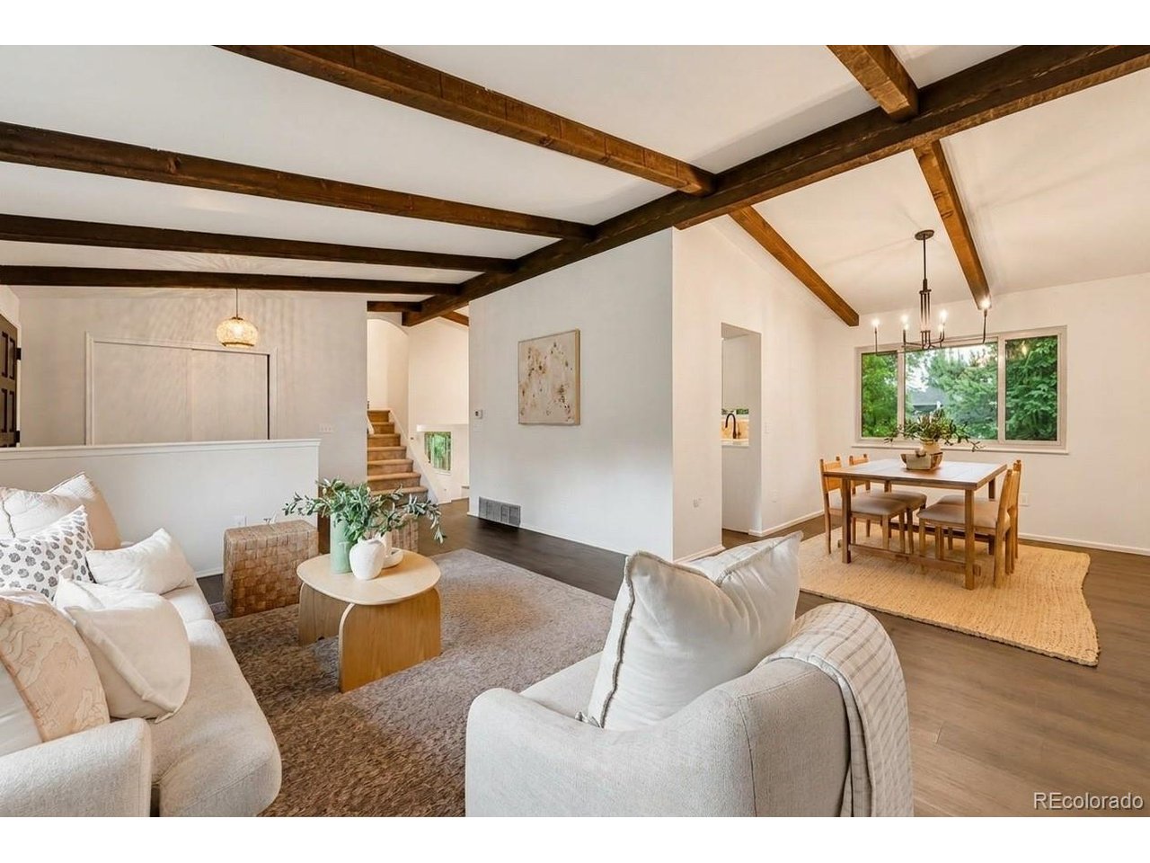 Welcome home to this beautifully updated property, perfectly positioned on a spacious corner lot in popular Bear Valley Heights. Thoughtfully remodeled throughout, this home blends warmth, character, and modern style with plenty of space to gather and entertain. Step inside to a welcoming foyer that opens to the main living spaces, where vaulted wood-beam ceilings add grandeur and architectural character. The inviting living room flows into the dining area and centrally located kitchen-the true heart of the home. Beautifully updated, the kitchen features white shaker cabinetry, quartz countertops, a chic backsplash, and a charming eat-in nook perfect for casual meals and everyday gathering. The lower level offers an inviting family room with a wood-burning fireplace and stylish Serena & Lily wallpaper. A wet bar with countertop seating makes entertaining easy, while the powder bath and laundry room add convenience. Step directly outside to the private backyard framed by mature trees, where a brand-new concrete patio is perfect for outdoor dining and entertaining. With tons of additional yard space, there's plenty of room for games, pets, gardening, and activities. Upstairs, the spacious primary suite features a walk-in closet and beautifully remodeled bath with dual sinks, a walk-in shower, gorgeous tilework, and tasteful finishes. Two additional bedrooms and an updated shared bath complete the upper level. The basement provides flexible bonus space for a non-conforming bedroom, recreation room, home gym, office, or a combination of it all. This home is as functional as it is beautiful, with brand-new A/C, a fully serviced and certified furnace, a roof in great condition with a five-year roof certificate, and a sewer line that has already been repaired for added peace of mind. Beautifully updated, full of character, and offering fantastic indoor and outdoor living, this Bear Valley Heights home is ready to be enjoyed.