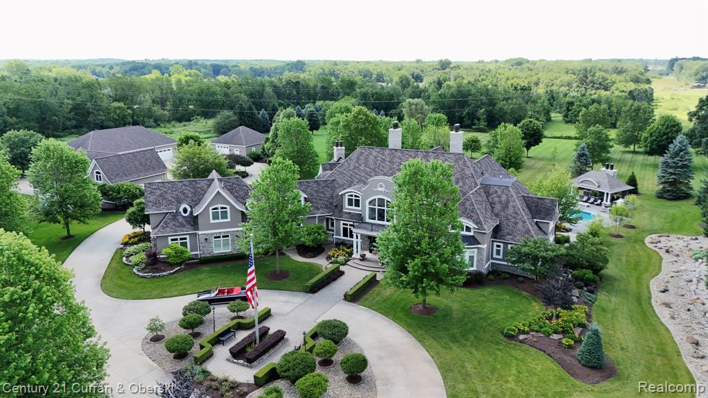 Introducing a truly one-of-a-kind gated estate in South Lyon, crafted by renowned builder Patrick Widing Custom Homes, a car collector’s dream and an entertainer’s paradise. This meticulously designed Country French Colonial spans 8.95 acres and over 15 million dollars has been invested into creating this world class property. Boasting over 9,800 sq ft above grade (plus a 5,324 sq ft of finished lower level), the home includes a private guest house, 6 bedrooms, 7 full and 1 half baths, and top-tier luxury finishes throughout. The first-floor primary suite features a fireplace, hardwood floors, marble spa bath with heated floors, and quartz countertops. The estate is ideal for automotive enthusiasts with multiple structures housing over 30 cars, a mechanic's dream garage. Outdoor highlights include a new $700K resort-style pool and pool house, a 4-hole par-3 golf course, and professionally landscaped grounds offering unparalleled privacy and serenity. Inside, you'll find an exquisite study with judges paneling, multiple limestone fireplaces, a phenomenal gourmet kitchen, a sunroom, and a family room designed for relaxation and entertaining. The lower level features a full kitchen, bar with custom millwork, home theater, temperature-controlled wine cellar, and elevator access. Over $250K in custom lighting and Control4 smart home automation elevate this estate to a new level of luxury. Every inch is well-appointed with detailed woodwork, soaring ceilings, and panoramic views.This is more than a home, it's a private resort estate unlike anything else on the market.