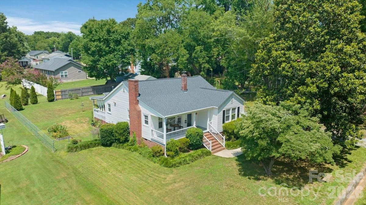 Classic charm, generous living spaces, and an oversized lot come together at this beautifully maintained home just minutes from the heart of Kannapolis. From the inviting covered front porch to the mature landscaping, this home offers timeless curb appeal and a warm welcome from the moment you arrive.Inside, you'll find gorgeous hardwood floors, abundant natural light, spacious living and dining rooms, and two oversized bedrooms that provide flexibility for guests, a home office, or everyday living. The kitchen offers ample cabinet space, a bright breakfast area, and easy access to the backyard.Step outside and enjoy one of this property's standout features—a fully fenced .38-acre yard with plenty of room for pets, gardening, entertaining, or simply relaxing outdoors. The attached carport provides covered parking while the detached storage building offers excellent space for hobbies, lawn equipment, or additional storage.Conveniently located near downtown Kannapolis, shopping, dining, parks, medical facilities, and major commuter routes, this home combines character, functionality, and location in one exceptional package. Whether you're purchasing your first home, downsizing, or searching for an investment opportunity, this property is one you won't want to miss.
