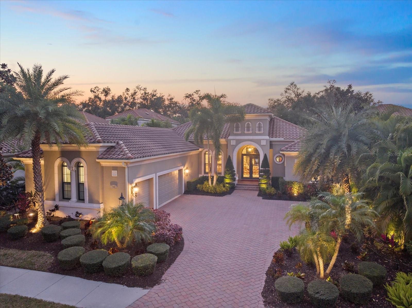 This stunning residence, located in Lakewood Ranch Country Club,  perfectly blends luxury, comfort, and functionality. This meticulously designed home offers 3,698 square feet of living space under air, featuring 3 bedrooms, 3 baths, an office, and a bonus room. With an additional 690 square feet of covered lanai and nearly 3,000 square feet of screened-in outdoor living space, this home is ideal for entertaining and enjoying Florida’s beautiful weather. Imagine relaxing on the lanai, watching breathtaking sunsets over the golf course, or hosting unforgettable gatherings in this thoughtfully designed space.From the moment you arrive, the home’s grand entry makes a statement with oversized double iron doors featuring impact glass and a transom above, complemented by decorative tile flooring. Inside, the attention to detail is evident with crown molding, plantation shutters, and decorative wall and ceiling treatments throughout. Engineered hardwood and tile flooring flow seamlessly through the home, while custom built-in closets and cabinetry provide both style and functionality.The heart of the home is the chef’s kitchen, which boasts an oversized island with quartz countertops, GE Monogram appliances, including a six-burner gas stove, microwave, oven, refrigerator, and dishwasher with cabinet panels. A custom wooden hood, glass cabinets, marble backsplash, and an aquarium glass window in the eat-in kitchen add to the elegance. Pendant lighting creates a warm and inviting ambiance, making this space perfect for both cooking and gathering.The living room is equally impressive, featuring tongue-and-groove wall treatments, coffered ceilings, recessed lighting, and pocket sliding glass doors that open to the expansive lanai. The dining room is a refined space with a decorative mirror wall, tray ceiling, chandelier, and a dry bar complete with a wine fridge and glass doors. The primary suite is a private retreat with a vestibule entry, dual walk-in closets with custom built-ins, a coffered ceiling with tongue-and-groove detailing, and French doors with clear impact glass that lead to the lanai. The spa-like primary bath offers dual split vanities with quartz countertops, a tub with wood surround, a walk-in shower with tile to the ceiling, and ample storage with a linen closet and water closet.Step outside to your private oasis, where the saltwater pool with a fountain and spa is perfectly situated to take in the serene golf course views. The oversized covered lanai, complete with ceiling fans, provides a comfortable space to relax or entertain, while the outdoor kitchen, featuring a grill, sink, beverage fridge, and bar, makes hosting a breeze. Whether you’re enjoying a quiet evening watching the sunset or entertaining friends and family, this outdoor space is truly exceptional.The oversized 3-car garage is a standout feature, offering high ceilings, custom cabinets, a mini-split system for climate control, and speckled epoxy flooring. Additional highlights of the home include landscape lighting, stem wall construction, and decorative molding throughout. Every detail of this home has been carefully considered to provide a luxurious and welcoming living experience.