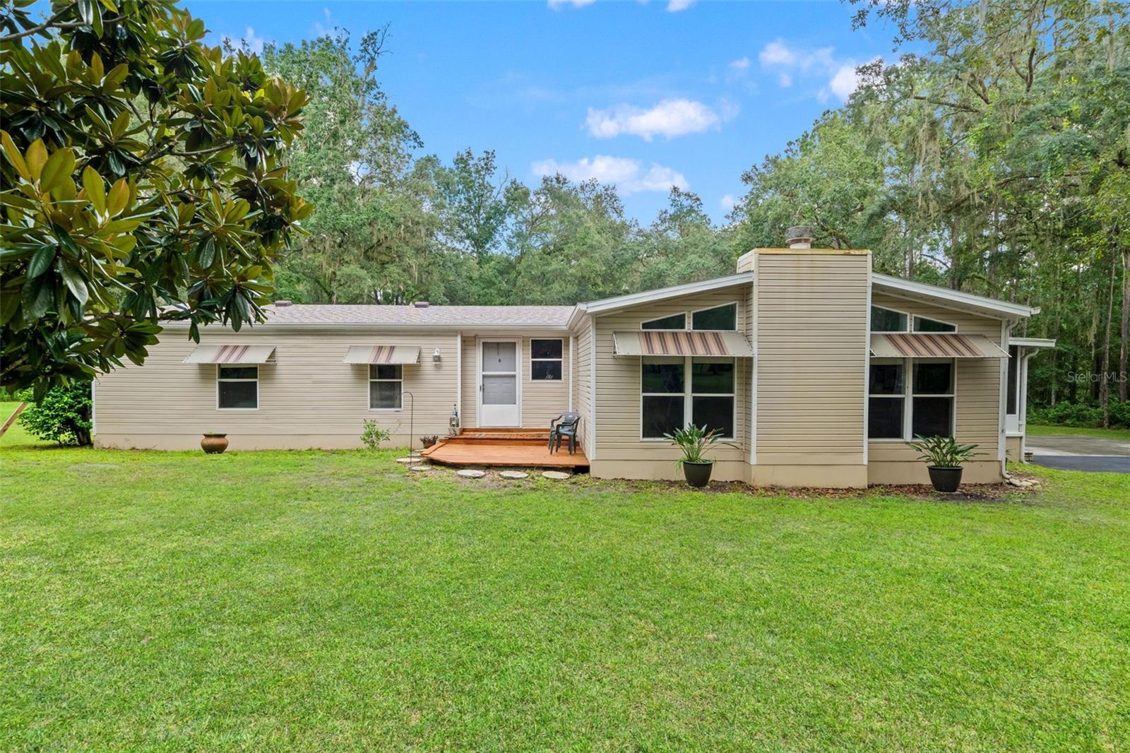 Space, privacy, and a beautiful park-like setting come together on this 2.5-acre Brooksville property! Surrounded by mature oaks and plenty of room to spread out, this 3-bedroom, 2-bath manufactured home has been loved by the same family for more than 25 years and is ready for its next chapter. Two major improvements are already complete, including a full roof replacement in January of 2025 and HVAC system replacement in 2022. Inside, the home offers three spacious bedrooms with ample closet space, a living room, dining room, and separate family room anchored by a wood-burning fireplace with a stone façade. The primary bedroom features an ensuite bathroom with a soaking tub and separate shower. A water softener and reverse osmosis system are also in place, while the private well and septic system mean no monthly water bill. Step outside to the screened side porch and take in the peaceful surroundings, beautiful oak trees, and visiting wildlife. With 2.5 acres and no HOA, there’s plenty of room for your toys, outdoor projects, and plans for the property. An oversized shed provides additional space for tools, equipment, and storage. Tucked away while still offering convenient access to US 41 and I-75, the property is just minutes from Downtown Brooksville and its local shops, restaurants, events, and small-town charm. If you’re looking for acreage, privacy, room to spread out, and important updates already completed, this Brooksville property deserves a closer look!