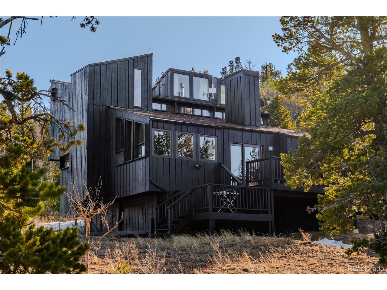 Rarely does a property combine this level of privacy, character, and direct access to the Colorado mountains just minutes from the heart of Nederland. Bordering National Forest, this one-of-a-kind retreat blends contemporary mountain design with rustic Colorado charm, offering the feeling of true seclusion while keeping downtown Nederland and Eldora within easy reach.Inside, warm rustic character blends with thoughtful modern updates and abundant natural light. The open floor plan creates an inviting space for gathering, with a double-sided gas fireplace connecting the living and dining areas and large windows bringing the surrounding mountain landscape indoors. The primary bedroom is currently designed as an open loft, creating an airy architectural feel, with the flexibility to easily enclose the space for additional privacy.Step outside and National Forest is quite literally your backyard, with hiking and exploring right out the door. After a day on the trails or slopes, unwind under the stars in the included wood-burning hot tub and take in the peaceful mountain setting.Sold fully furnished and ready to enjoy from day one, this is an ideal opportunity for a full-time mountain residence or turnkey second home. Enjoy the privacy and peaceful setting of a mountain retreat while remaining just minutes from the shops, restaurants, and character of downtown Nederland and a short drive to Eldora Mountain Resort.