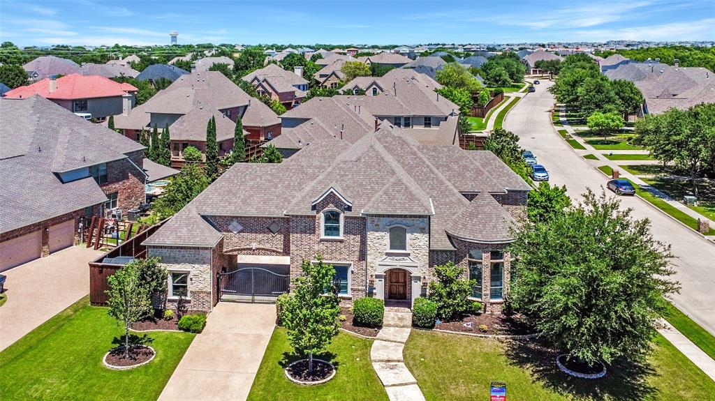 Welcome to this sprawling, elegantly appointed home located in the highly coveted Country Club Ridge at The Trails neighborhood. Designed for both refined living and comfortable entertaining, this luxurious residence offers 5 bedrooms, soaring ceilings, and an open-concept layout filled with upscale details.

Upon entry, you'll be greeted by a warm, inviting atmosphere and stunning architectural elements. The main living area showcases rich hardwood floors, wood-beamed ceilings, a striking stone fireplace, and custom built-ins that add charm and functionality. The chef’s kitchen is a true centerpiece, featuring a breakfast bar island, top-of-the-line stainless steel appliances, a walk-in pantry, and a dedicated work area, ideal for everyday living. A formal dining room provides a sophisticated space for hosting, while a generously sized home office with towering ceilings offers a quiet, professional retreat.

The main floor includes a luxurious primary suite, along with a spacious secondary bedroom featuring a walk-in closet —perfect for guests or multigenerational living. Upstairs, you'll find a large game room, a media room, and three generous sized bedrooms—each with walk-in closets—and two full bathrooms.

Step outside to your private outdoor oasis, complete with a sparkling pool and spa, a tranquil water feature, an outdoor fireplace, and two covered patios perfect for year-round enjoyment. Additional features include a gated driveway and a porte-cochère for added convenience and curb appeal.

Located in the award-winning Frisco ISD, this home is just a short walk from The Trails Golf Course and Fairway Green’s Park, offering a community pool, playground, and scenic green spaces. This exceptional property combines luxury, comfort, and an unbeatable location—an opportunity not to be missed.