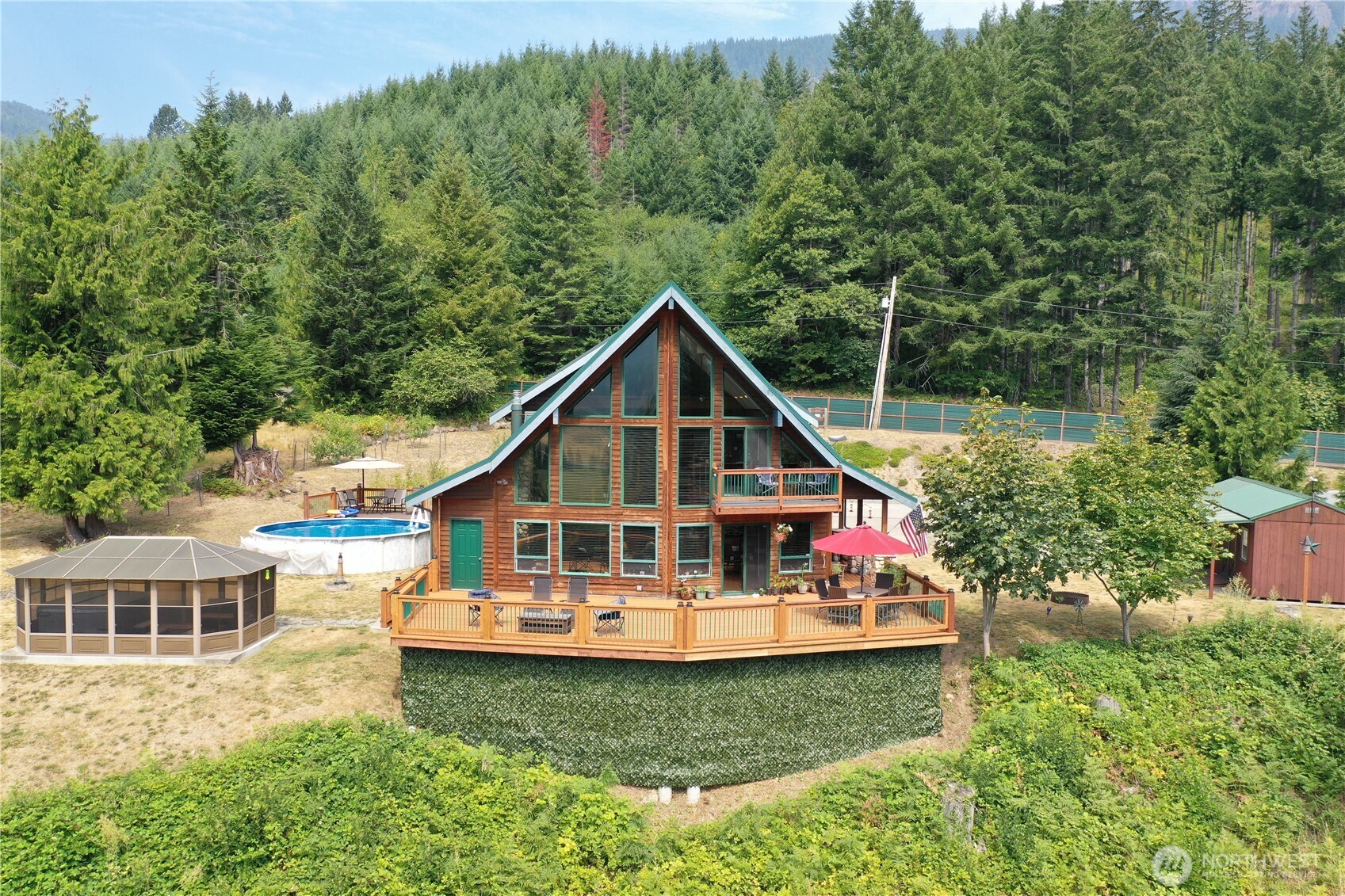 Perched above the Cowlitz River, with nearly 300’ high bank river frontage and a seasonal creek with direct river access, this 2.11-acre property with a large 3-bedroom, 2.5-bath home pairs Pacific Northwest character with sweeping river, valley, and mountain views. A dramatic wall of windows fills the vaulted great room with natural light, while warm wood ceilings, stone hearth and exposed beams create an inviting lodge-inspired atmosphere. The kitchen offers generous cabinetry, stainless appliances and ample workspace. Flexible loft space for an additional living area and office, plus a spacious upper-level primary suite, provide room to gather, work, or unwind. Outside, an expansive deck overlooks the river and surrounding landscape - an exceptional setting for outdoor entertainment and year-round scenery. An oversized, attached 2-car garage with workspace plus a detached 2-car shop with an air compressor is ready for all your projects. Additional highlights include an above-ground pool with its own deck, screened outdoor hot tub cabana for year-round comfort, established grounds, and plenty of storage. The automatic generator is installed and ready to go. Ask your broker for the full list of updates and upgrades! Conveniently located near Packwood and the recreational opportunities of the White Pass corridor; make this your very own PNW paradise.