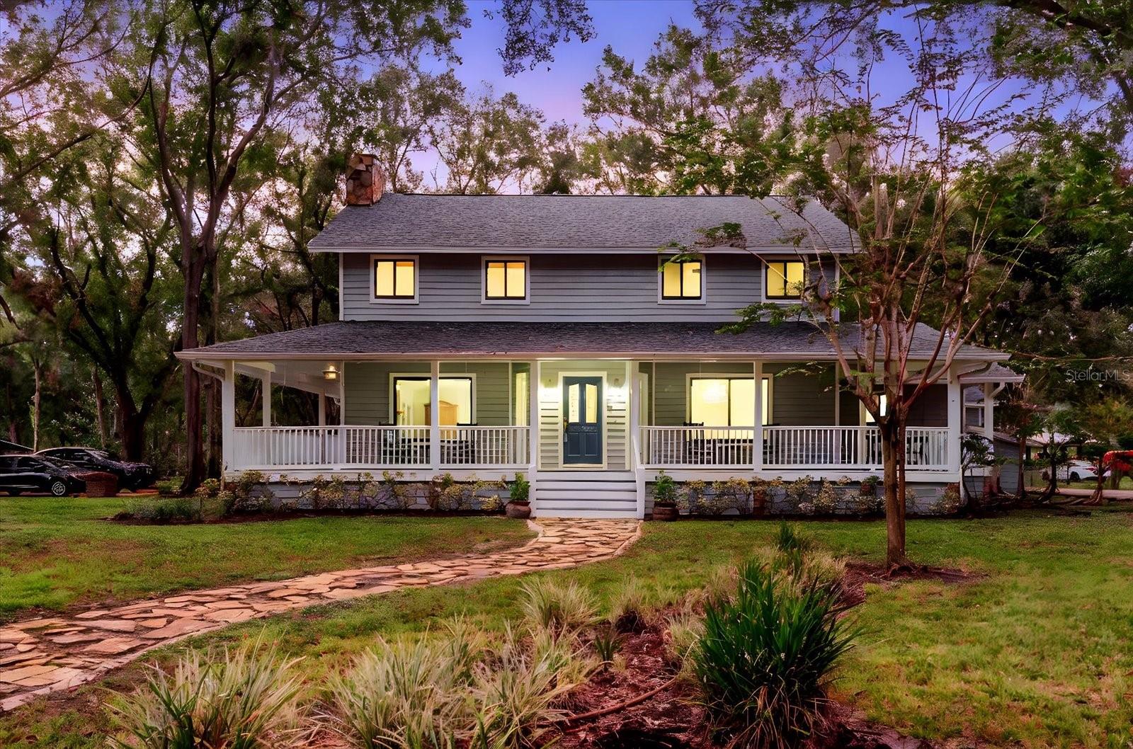 One or more photo(s) has been virtually staged. Enjoy 3.16 acres of no-HOA, no-CDD, freedom with this modern farmhouse featuring 4,563 sq. ft. (main house Under roof) and nearly 3540 sq. ft. of Garage/workshop areas. Highlights include a wrap-around porch, brand-new roof, three new AC units, and two primary suites one on each level plus two oversized bedrooms and a renovated bath. The massive block Garage building offers an 840 sq ft of climate-controlled storage, an office space and or Gym, an upstairs 840 sq ft studio with full bath and wet bar, ideal for guests or an in-law suite,  and an RV/boat/car lift space. A third block detached building workshop adds even more possibilities. All of this sits on roughly two-thirds of the property, with a separately fenced 1-acre section ideal for horses, a barn, gardens, or additional storage. Located just minutes from shopping and dining, yet offering the peaceful privacy of country living. The property is fully fenced and gated. all just minutes from shopping and dining yet surrounded by peaceful privacy.