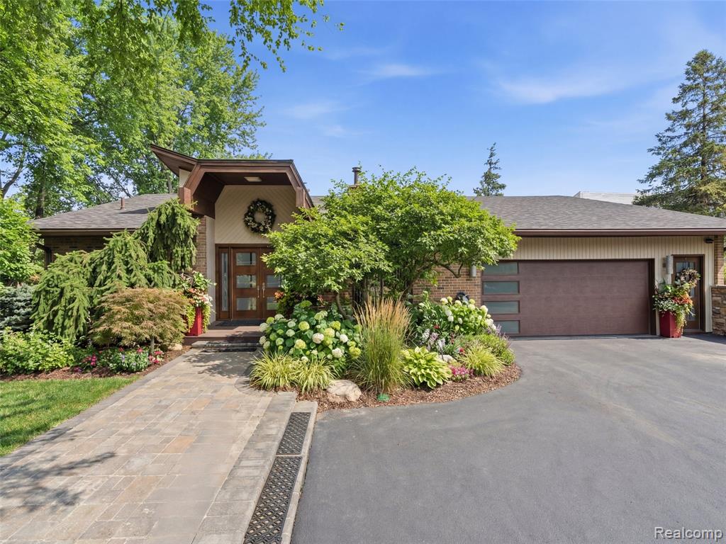 Nestled in the highly desirable Walnut Lake Hills subdivision, this distinctive contemporary quad-level home offers access to a private beach, park, gazebo, and boat docking (by rotation) on all-sports Walnut Lake—just a short walk away.Featuring one-of-a-kind architecture, the home showcases soaring ceilings, an open floor plan, and expansive windows that flood the interior with natural light. The flexible layout includes a formal dining room, den, and a dramatic great room anchored by a striking stone fireplace with built-in features.The bright white kitchen combines style and function with granite countertops (2022), an artistic china backsplash, stainless steel appliances (2022), and a wine cooler (2022).The entire upper level is dedicated to a luxurious primary suite retreat, complete with a massive closet, dressing area, and a beautifully remodeled bath (2023) featuring a tub, shower, and private balcony. One level below, a private three-bedroom wing with a full bath offers ideal separation for family or guests.The finished walk-out lower level expands the living space with a family room, full bath, bar area, cedar closet, and abundant storage. Additional fireplaces installed in 2023 enhance the ambiance in the primary bedroom, den, and lower level.This home has seen extensive updates, including interior and exterior painting (2022), new roof and gutters (2023), two furnaces and two air conditioning units (2023), carpet throughout (2023), vinyl basement flooring (2023), and a stunning front entry with travertine marble flooring (2024). Outdoor improvements include a new walkway and back patio (2024), updated landscaping with lighting (2024), and a freshly blacktopped driveway (2025).Situated on a quiet cul-de-sac, this property offers incredible potential—blending major mechanical and aesthetic updates with the opportunity to further personalize and elevate its unique design.Located within the highly acclaimed Bloomfield Hills School District, this is a rare opportunity to own a truly special