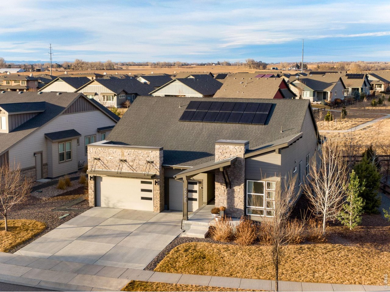 Experience refined Colorado living in this beautifully designed modern ranch backing to community open space with peaceful north-facing views. Enjoy cool summer evenings on the covered back deck overlooking the open space, offering privacy and a true indoor-outdoor lifestyle.This sprawling 5,099 total sq ft home features 100% main-floor living with 4 bedrooms and 3 bathrooms in a thoughtful split floor plan. High ceilings, 8' doors, wood flooring, and a bright open layout create a clean, modern aesthetic highlighted by white quartz countertops throughout.The chef's kitchen is built for both function and entertaining, offering stainless steel appliances including double ovens, a large quartz island, walk-in pantry, and seamless flow into the living room with a gas fireplace. A formal dining room provides space for gatherings and special occasions.The spacious primary suite captures open space views and includes a large walk-in closet and an oversized shower with poured pan for a luxurious retreat experience. An unfinished basement provides significant future expansion potential or abundant storage. The 3-car garage and solar panel system enhance both convenience and energy efficiency. Located in highly desirable Wildwing community featuring four neighborhood parks, walking and bike paths, an outdoor pool, and access to Timnath Reservoir. This home delivers lifestyle, space, and long-term value in one exceptional package!