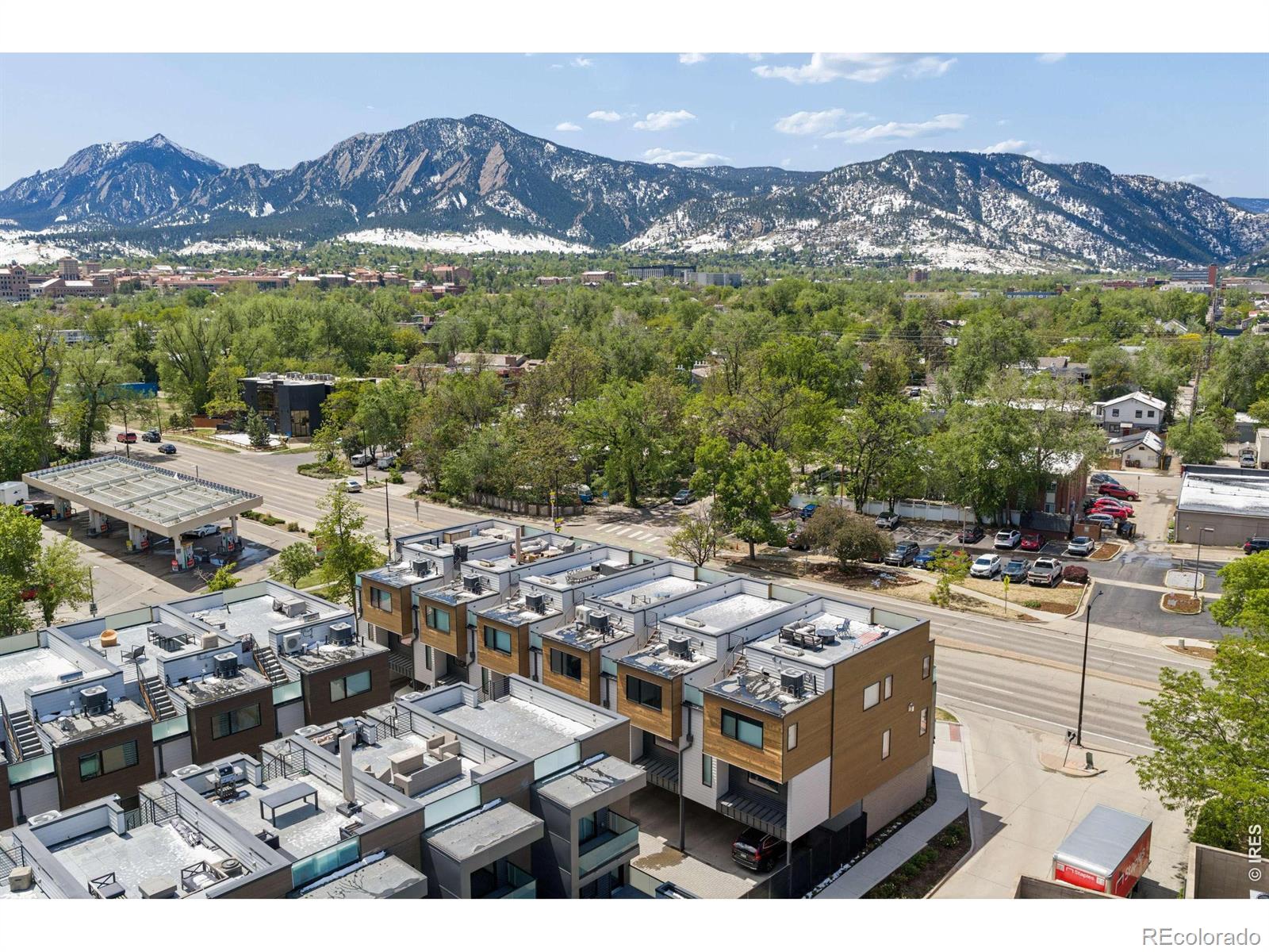 Flatiron Vista Residence. Elevated modern living meets iconic Boulder scenery in this luxury townhome, positioned in one of Boulder's most walkable locations. Built in 2021, this sophisticated residence blends sleek contemporary design with effortless indoor-outdoor living, all framed by breathtaking Flatiron views from every level. Moments from campus, restaurants, shopping, and downtown Boulder, the location delivers unmatched convenience with an elevated feel. A welcoming front patio creates an inviting arrival, while the gated rear carport entry offers privacy and function. Inside, expansive living spaces are filled with natural light and curated finishes. The main living level is designed for refined entertaining and everyday comfort, featuring a chef's kitchen with premium Viking appliances, an oversized island with breakfast bar, abundant cabinetry, and seamless flow into the dining and living areas. A striking gas fireplace anchors the living room, while an adjacent terrace extends the space outdoors with sweeping Flatiron vistas. Designer lighting adds warmth and sophistication. The versatile entry level includes a spacious bedroom and full bath, ideal for guests, a home office, or multigenerational living. Upstairs, the primary suite serves as a private retreat with its own terrace, custom walk-in closet, and spa-inspired ensuite bath with an oversized dual-head shower. A bright secondary bedroom with a beautifully appointed 3/4 bath completes the third level. Crowning the home is a spectacular rooftop terrace designed for unforgettable entertaining and sunset evenings beneath the Colorado sky. Complete with a built-in outdoor kitchen, grill, and granite countertops, this elevated outdoor sanctuary captures some of the most stunning Flatiron views in Boulder. Generous crawl-space storage adds exceptional convenience and flexibility. Rare opportunity to experience modern Boulder luxury with iconic views, premier walkability, and exceptional design.