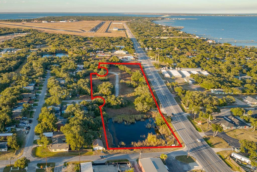 Prime 6.5-acres lot for development opportunity in Fulton (Rockport) with over 733 feet of HWY 35 Business frontage! This corner lot features a small pond, mature windswept live oaks, and secondary road access. City water and sewer available to be connected. Just blocks from the Fulton fishing pier, harbor, restaurants, and minutes from Rockport Beach and artsy downtown. Don't miss this chance to invest in a thriving coastal community! Not many like this left, hurry!