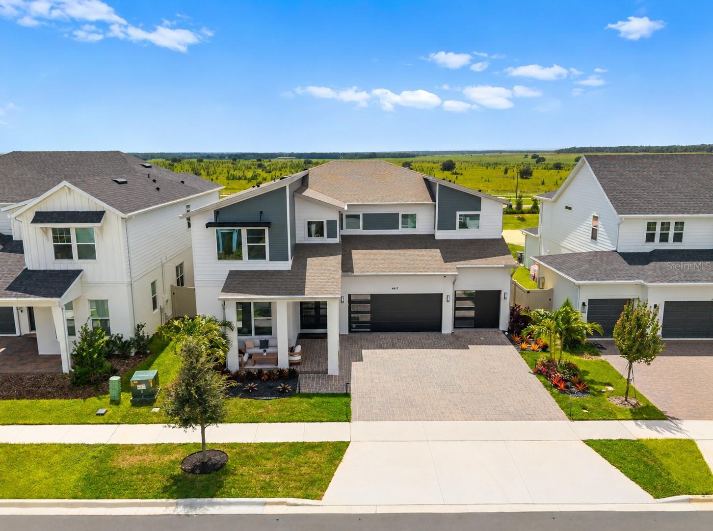 CUSTOM BUILT IN 2025 and READY NOW in Clermont’s sought after PARKSIDE TRAILS! Offering OVER 4,000 SQ FT, 5 BEDROOMS PLUS AN OFFICE and flexible living spaces, this light filled home combines extensive builder selections with improvements completed after construction. A COVERED FRONT PORCH, tropical landscaping, landscape lighting, ProVista sod and double entry front doors welcome you home. CUSTOM GARAGE DOORS, upgraded fixtures and hardware, LUXURY VINYL PLANK AND TILE FLOORING, engineered hardwood stairs with porcelain tile risers and upgraded cabinetry add detail throughout. The interior has been freshly painted, while the SATIN EXTERIOR PAINT carries a transferable eight year warranty. Refinished kitchen cabinetry carries a transferable lifetime warranty. The main floor features a dedicated OFFICE/FLEX SPACE, FORMAL DINING ROOM, private BEDROOM SUITE and additional guest bath with exterior access, ideal for a FUTURE POOL. A dramatic TWO STORY LIVING ROOM with catwalk views opens to the casual dining area and CHEF’S KITCHEN. Floor to ceiling cabinetry with crown molding, sleek countertops, BUILT IN STAINLESS STEEL APPLIANCES, a GAS COOKTOP, oversized ISLAND with bar seating and pendant lighting, a beverage cooler and a BUTLER’S PANTRY connecting to the formal dining room make entertaining easy. Under cabinet lighting, a kitchen reverse osmosis system and thoughtful storage add everyday function. Cambria quartz floating shelves and an entertainment center with a black quartz countertop and LED lighting complete the gathering space. Upstairs, the OVERSIZED PRIMARY SUITE offers a sitting area, TWO WALK IN CLOSETS and a SPA LIKE EN SUITE BATH with an upgraded glass shower and tile extended to the ceiling. Three additional bedrooms include a SECOND BEDROOM SUITE and two bedrooms sharing a JACK AND JILL BATH. The upstairs laundry includes added cabinetry, a countertop, sink, floating shelves and hanging bar. Custom storage shelves, a mudroom bench and cabinetry, and a closet system and TV console in the multigenerational suite give every space a purpose. A whole home water softener, modern lighting and fans, and an EPOXY GARAGE FLOOR add to the improvements. Outside, the COVERED LANAI is PREPLUMBED FOR AN OUTDOOR KITCHEN, with wiring for a future pool or spa. It overlooks a partially fenced backyard with NO REAR NEIGHBORS and room for your dream pool. The driveway and lanai pavers have been sealed, and the seller reports views of MAGIC KINGDOM AND EPCOT FIREWORKS from the backyard. PARKSIDE TRAILS is a newer community with OPEN TENNIS AND PICKLEBALL COURTS AND PLAYGROUNDS. A clubhouse is under construction, with a resort style pool, cabana and fitness center planned. The HOA INCLUDES 1 GIG INTERNET AND CABLE. The home is zoned for SAWGRASS BAY ELEMENTARY, WINDY HILL MIDDLE AND EAST RIDGE HIGH. Enjoy easy access to US 27 and SR 429, and proximity to Orange County National Golf Center and Lodge, Disney parks, shopping, dining and lakes. Why wait to build when this CUSTOMIZED HOME is finished, upgraded and READY NOW? YOUR DREAM HOME AWAITS!
