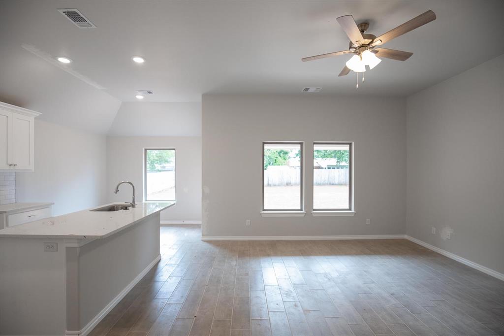 This Bogan floor plan includes 1,510 Sqft of total living space, which includes 1,400 Sqft of indoor living space and 110 Sqft of outdoor living space. There is also a 395 Sqft, two car garage with a storm shelter installed. This home offers 3 bedrooms, 2 bathrooms, 2 covered patios, an office, and a utility room. The living room welcomes wood-look tile, large windows, a ceiling fan, and Cat6 wiring. The kitchen has 3 CM quartz countertops, stainless-steel appliances, wood-look tile, custom-built cabinets with decorative hardware, and stylish tile backsplash. The primary suite features noteworthy carpet flooring, a ceiling fan, Cat6 wiring, and perfect-sized windows. The spacious primary bath offers a dual sink vanity with an elegant countertop selection, a walk-in shower, an elongated water saving toilet, and a walk-in closet! The outdoor living area is covered and has fully sodded yards with a water saving sprinkler system. Other amenities include a tankless water heater, a fresh air intake ventilation system, R-15 and R-38 insulation, an air filtration system, and so much more!