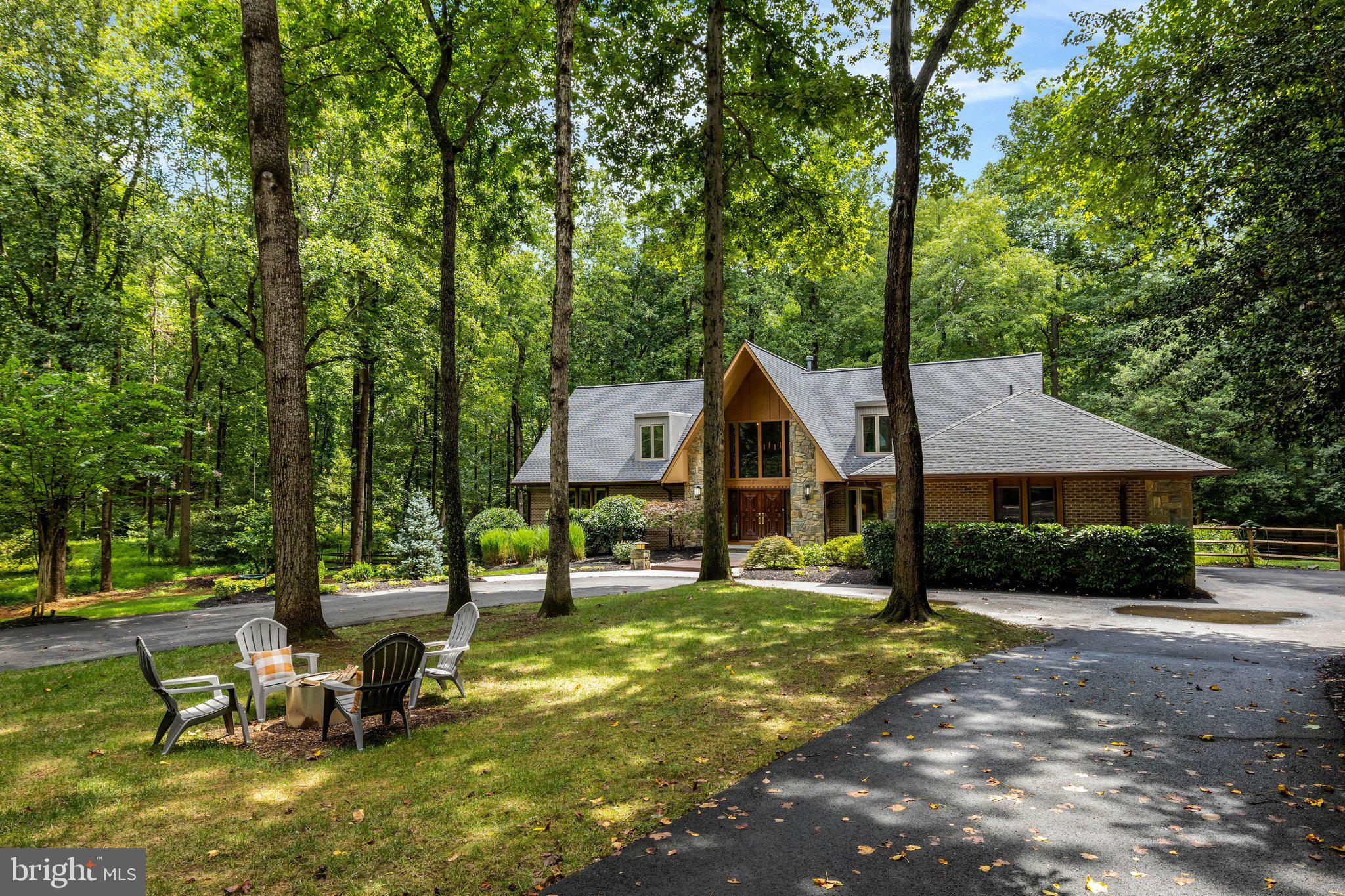 Luxury. Privacy. Nature. Timeless Architecture. Welcome to 11111 Lawyers Road, an extraordinary custom A-frame contemporary nestled on over 2 private acres in one of Reston's most coveted locations near the Oakton border. Offering 5 bedrooms, 4.5 baths, and over 5,300 square feet, this one-of-a-kind luxury home blends striking architecture, modern updates, and peaceful wooded surroundings just minutes from Reston Town Center, Metro, major commuter routes, shopping, dining, and top Fairfax County amenities.A circular driveway, natural stone accents, and handcrafted solid oak double doors create an unforgettable first impression. Inside, a dramatic two-story foyer showcases soaring ceilings, wide-plank hardwood floors, an open bridge, and views into the breathtaking Great Room with its vaulted ceiling and stunning wood-burning fireplace with 20-foot floor-to-ceiling stone hearth.Designed for both entertaining and everyday living, the spacious dining room flows seamlessly into the beautifully renovated gourmet kitchen featuring an oversized granite island with prep sink, premium Thermador refrigerator and six-burner gas range with griddle & pot filler, two dishwashers, beverage refrigerator, abundant cabinetry, and generous prep space. A mudroom with laundry provides convenient access to the freshly painted garage.The main-level primary suite offers a luxurious private retreat with a custom walk-in closet and a fully renovated spa bath featuring heated tile floors, oversized double shower, dual vanities, private water closet with bidet, and skylight. A dedicated home office with built-ins and skylight completes the main level.Upstairs are two expansive bedroom suites, each with renovated en-suite baths, walk-in closets, recessed lighting, and abundant storage.The finished walk-out lower level offers exceptional flexibility with multiple recreation spaces, a second wood-burning fireplace, two additional large bedrooms, an updated full bath, and unfinished storage ready for a workshop, home gym, or future finished space.Outside, enjoy your own private wooded retreat. A newly constructed deck with natural gas hookup is perfect for outdoor dining and entertaining. Professionally landscaped grounds, expansive lawn areas, mature trees, a charming tree swing, and a fire pit with Solo Stove create the perfect setting for relaxing or gathering with family and friends.Major updates include a renovated kitchen (2013), HVAC (2020), water heater (2021), new roofs (2023), and an extensive 2024 renovation featuring new main-level hardwood flooring, renovation of all five bathrooms, a redesigned primary suite, and Andersen replacement windows throughout the upper two levels.Rarely does a Reston home offer this combination of architectural distinction, luxury finishes, privacy, acreage, and modern updates. Whether you're seeking a private estate, luxury contemporary home, multigenerational living, or peaceful nature-filled surroundings with unbeatable convenience, 11111 Lawyers Road delivers an exceptional lifestyle unlike anything else on the market.  So come check it out, and prepare to fall in love.