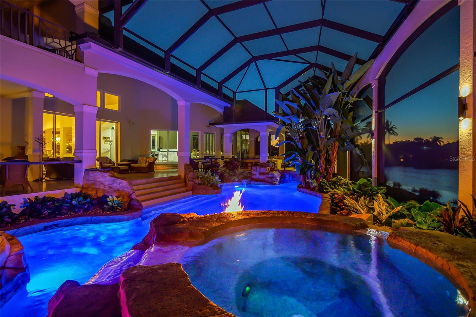 A RARE BONITA BAY ESTATE: EXCEPTIONAL SCALE, PRIVACY & VALUE ON A $2M LAKEFRONT LOTWelcome to 27201 Ibis Cove Court, an extraordinary custom estate set at the end of a quiet cul-de-sac on one of Bonita Bay’s most impressive homesites. Encompassing 0.70 acres of private lakefront property, the lot is valued at approximately $2,000,000, creating a remarkable foundation for this exceptional $4,900,000 offering.With 7,838 square feet of air-conditioned living space and 16,073 square feet of total lifestyle area, the residence offers an exceptional sense of scale while maintaining the comfort and privacy expected of a distinguished Florida estate. The thoughtfully designed floor plan includes 5 bedrooms, a private den, 5 full bathrooms and 2 half bathrooms.The grand salon is defined by soaring ceilings and a dramatic 30-foot Florida Keystone fireplace, creating an impressive setting for both entertaining and everyday living. The expansive main-level primary suite provides a private retreat with a luxurious spa-like bath and beautiful views. A dedicated home theater and two separate garages accommodating five vehicles—one four-car garage and one single-car garage—further enhance the estate's versatility and appeal to automobile enthusiasts.Beyond the main living spaces, the outdoor setting is truly exceptional. Previously featured in Naples Illustrated, the custom resort-style pool and expansive outdoor living area create a private oasis overlooking the lake. Five cascading waterfalls, an integrated swim-up bar, elevated spa, three fire features, custom water slide and elegant bridges create an extraordinary environment for entertaining or simply enjoying the serenity of the setting. The entire outdoor living area is screened for year-round enjoyment.Bonita Bay adds another dimension to the lifestyle, with a private beach club on Little Hickory Island, full-service marina and waterfront dining at Backwater Jacks, miles of walking and biking trails, and optional memberships offering championship golf, tennis and a state-of-the-art fitness complex.27201 Ibis Cove Court represents a rare combination of land, architecture, scale, privacy and resort-style living. With an approximate $2,000,000 land value alone, this exceptional estate offers an uncommon opportunity to acquire a property of this magnitude in Bonita Bay for $4,900,000. A truly distinctive Southwest Florida residence.