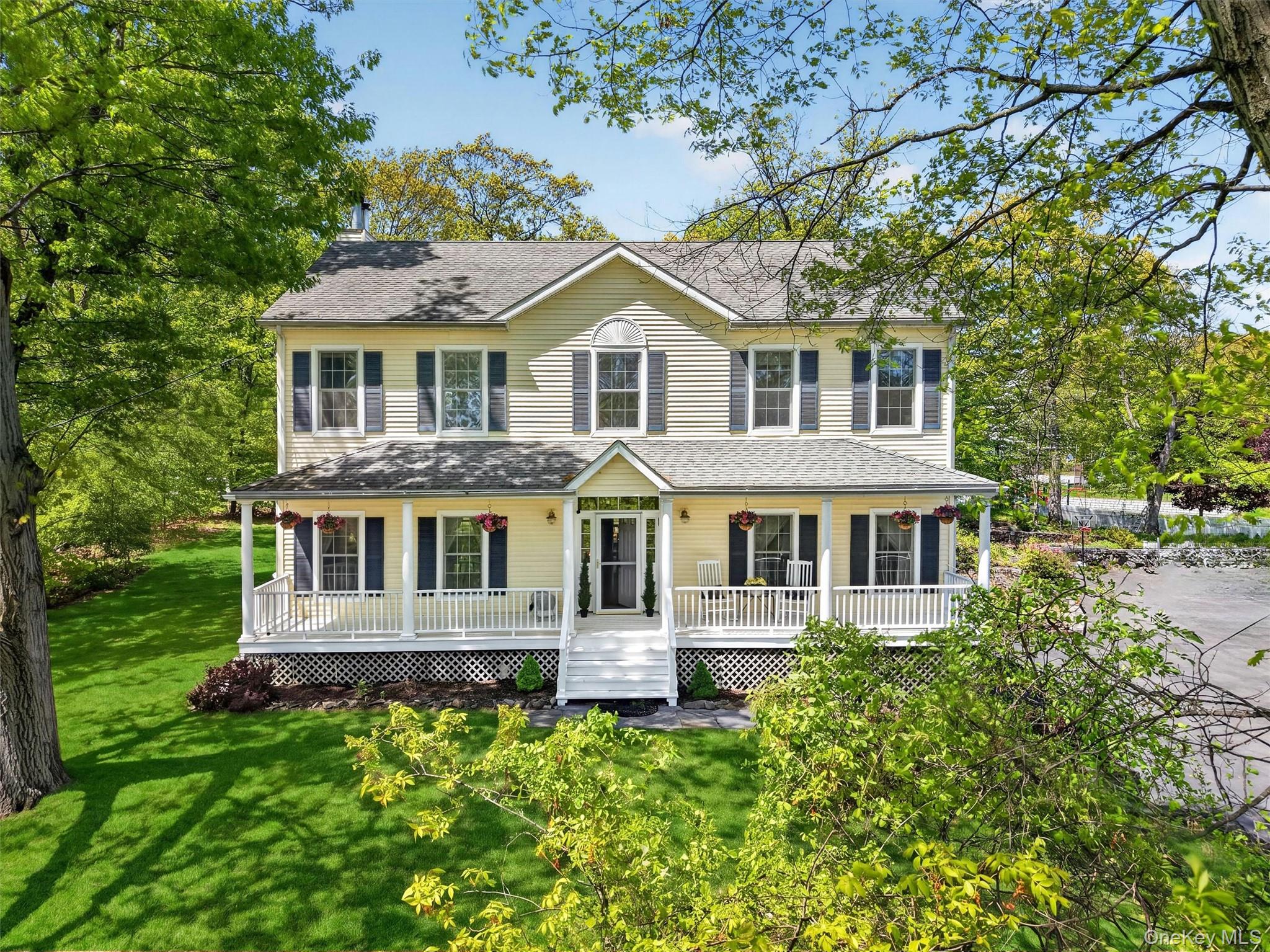 Classic Colonial set in the heart of Buchanan Village with scenic views of Lake Meahagh and a welcoming full-length front porch. This 4 bedroom, 3.1 bath home offers a comfortable and functional layout with hardwood flooring throughout the main level. The spacious kitchen features a peninsula, ample cabinetry, and a dining area with sliding glass doors to the deck seamlessly opening to a family room with fireplace. A formal living room, dining room, powder room, and mudroom complete the main level.  The upper level includes a primary suite with a walk-in closet and a large bath with jetted tub and separate shower, along with three additional bedrooms, a full hall bath, and conveniently located laundry. The finished lower level offers a versatile recreation room, full bath, and direct access to a two-car garage with high ceilings.  Set on .56 acres, the property also includes a rear deck for outdoor enjoyment and a new above-ground oil tank. Ideally located just moments from the village recreation center with pool, tennis courts, playground, pavilion, and playing fields. Enjoy peaceful walks around Lake Meahagh while being close to Metro-North, major highways, and everyday conveniences.