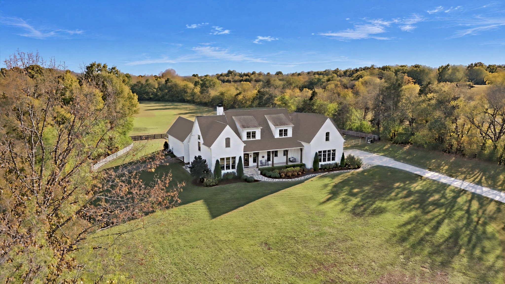 Tucked into the rolling hills of Williamson County, you’ll find an exquisite one-of-a kind home on 11.77 sprawling acres, allow me to introduce you to 6659 Flat Creek Road. Each square foot of this beautiful custom-build has been designed with intention, from designer curated finishes to hidden spaces, thoughtful details and a livable layout that creates a private retreat in the beautiful Tennessee countryside. As you pass through the gated entry, you’re met with a timeless brick exterior, flagstone walkway, lush landscaping and covered front porch. Just beyond the foyer, you’ll find the great room that is the heart of this home with high-ceilings, wood beams, a fireplace focal flanked with built-ins, abundant natural light flooding in through the large windows overlooking the property, and open to the gourmet kitchen, which is both a chef and entertainer’s dream. Off the kitchen is the butler’s pantry with bountiful storage – connecting directly into the formal dining with antique wood doors. Take everyday living outdoors, with the covered entertaining space including a fireplace and outdoor kitchen, centered around the in-ground saltwater pool and hot tub – with breathtaking views over the back acreage of the property. The private primary includes a double-sided fireplace, sitting area, spa-like bath, oversized walk-through closet with floor to ceiling storage which ties directly into the laundry room with dual sets of washer/dryers. Rounding out the first floor is the bonus room offering entertaining space with a full bar; a dedicated home gym with sauna and spectacular views, and a secondary en-suite. Upstairs are two well-sized bedroom suites with jack and jill style bath; plus, a dedicated study, craft room, a hidden safe room and an additional 365 sf of unfinished potential for a great home studio, playroom or additional bedroom. Offering more details than can be mentioned, a walk around this property is the only way to fully take in all that it has to offer!