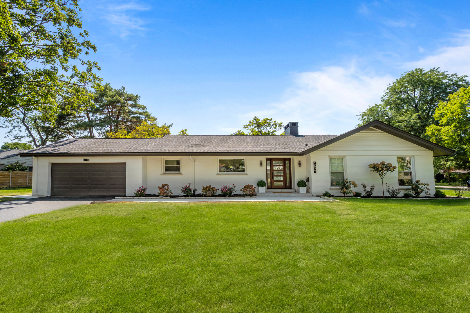 Set on an expansive lot in Wilmette, 2639 Marian Lane is a stunning renovation that seamlessly blends clean, modern design with timeless details. With four bedrooms and three full baths, this home offers a rare first-floor primary suite, gorgeous finishes throughout, and seamless indoor-outdoor living. Inside, natural light pours through a wall of windows, highlighting the open-concept living and dining areas. The sleek kitchen is a showpiece featuring dolomite countertops in a leathered finish, custom cabinetry, and top-of-the-line appliances, offering abundant storage and generous workspace. An airy living room anchored by a stone fireplace flows to the dining area and out to the patio, creating a true extension of the living space. Just off the kitchen, a mudroom and attached two-car garage provide practical everyday convenience. The primary suite is a serene retreat with custom built-in closets and a spa-inspired bath featuring dual stone sinks and a walk-in shower. Two additional bedrooms, a stylish full bath, and first-floor laundry complete this level. A beautiful open staircase leads to a spacious lower-level family room, a fourth bedroom, and another full bathroom. Outside, the expansive patio and lush yard invite easy entertaining and everyday relaxation. Beautifully reimagined by renowned architect Robert Surman, 2639 Marian Lane's modern finishes, functional floor plan, and ideal location offer the best of North Shore living.