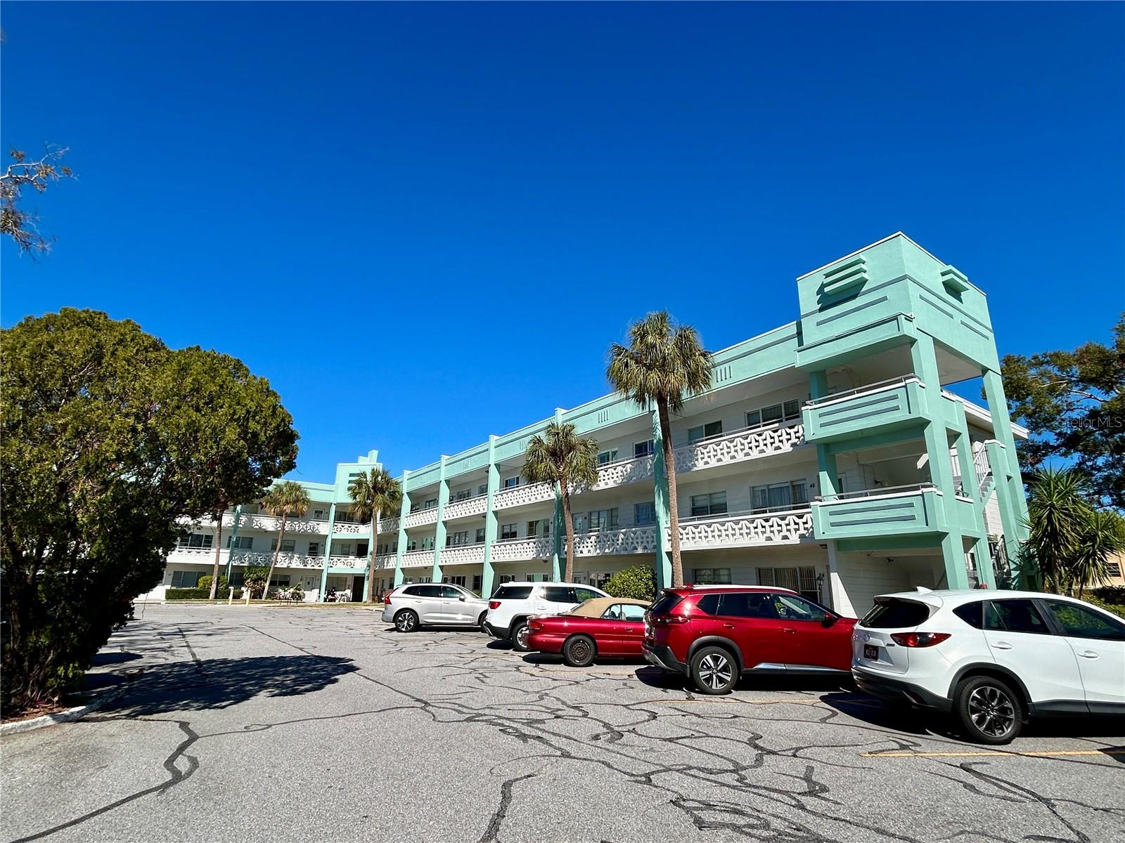 Welcome home to this first floor 2 bedroom, 2 bath condo in the highly sought after community of On Top of the World in Sunny Florida.  This unit has a newer A/C and newer washer and dryer. Enjoy a hot cup of coffee on the front patio or cocktails in the evening on the back porch underneath a beautiful overhang, complete with pull down shades to block out the sun. This first floor condo also includes a parking space that lies directly in front of your door. Enjoy all the great amenities On Top of the World has to offer including two golf courses (free to owners), two pools (one heated), tennis courts, shuffleboard, pickleball, billiards, dog park, state of the art fitness center, clubs, entertainment and much more. Located close to award winning beaches, great restaurants, shopping, medical and 25 minutes to Tampa International Airport. All room sizes, floor plans and square footage are approximate. This property is being transferred by a leasehold estate deed. Association approval is required. If financing, a 35% down payment is required. Washer, dryer, and hook ups must be approved by the association.
