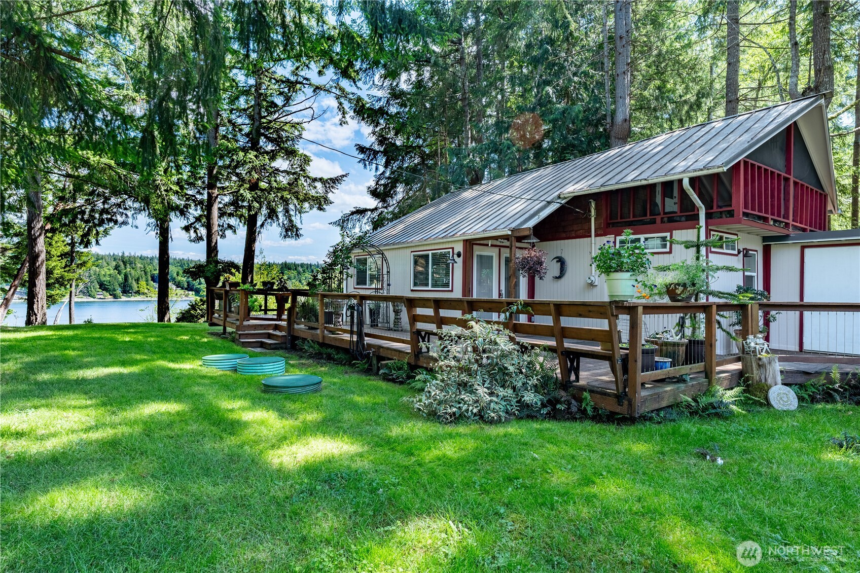 Perched above 60 feet of east-facing waterfront, including tidelands, this inviting island cabin offers the kind of peaceful escape that feels worlds away from the city — yet close enough for an easy weekend retreat. From its medium-bank setting, enjoy sweeping water views and breathtaking sunrises that greet you each morning in soft coastal light.  Inside, the open living, dining, and kitchen area creates a relaxed gathering space — ideal for slow mornings, shared meals, and reconnecting without distractions. A ¾ bath and laundry are conveniently located on the main floor. Upstairs, two cozy bedrooms provide restful retreats, with the larger bedroom opening onto a covered deck — a quiet perch for morning coffee and the gentle rhythm of island life.  The expansive wooden deck invites long, unhurried afternoons and easy evenings outdoors. The level 0.41-acre lot offers space to garden, play, or simply breathe a little deeper and enjoy the privacy.  Whether you're looking for a weekend getaway from the city or a simpler full-time lifestyle, this cabin delivers water views, coastal charm, and that unmistakable sense of calm that only island living provides.  A covered trailer is included at no cost to the buyer for overflow guests (or can be removed if preferred) and the 20’ x 18’ powered metal shop adds flexibility for storage, hobbies, or all your island gear.Wake with the sun, slow your pace, stay awhile!  Community features: boat ramp, seasonal boat docks plus so much more!