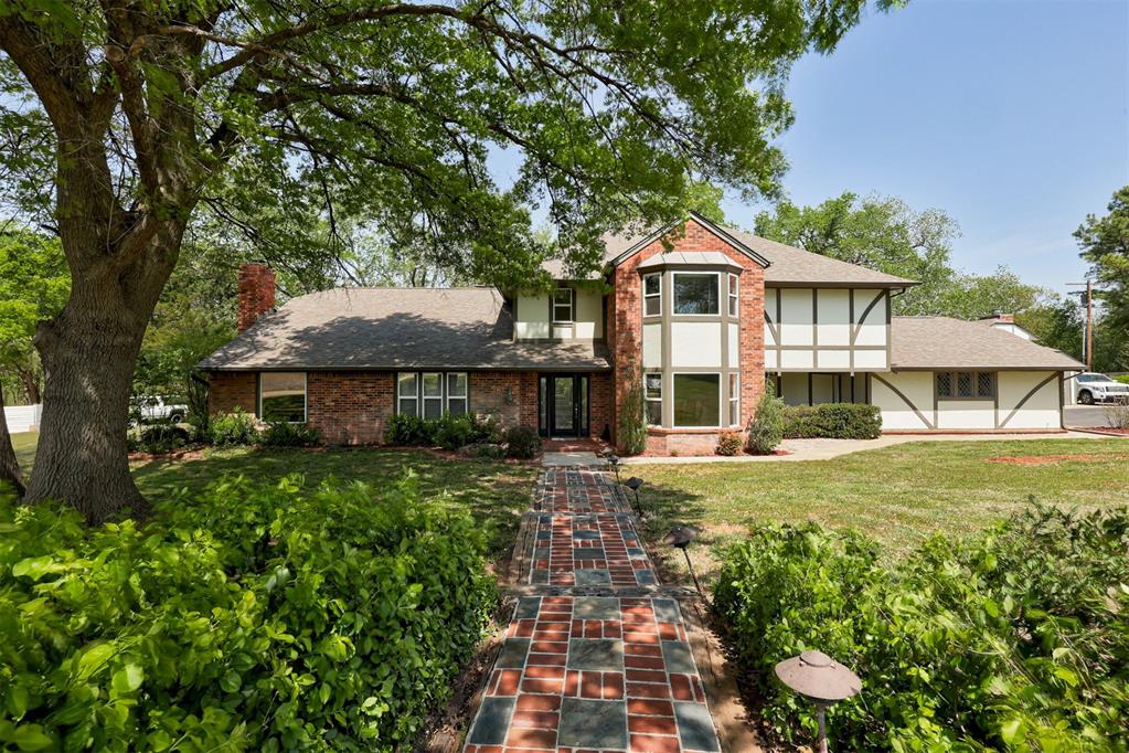 VA ASSUMABLE LOAN AT 2.25%!! Tucked at the end of a quiet cul-de-sac on 2 private, tree-lined acres, this Tudor-style home offers the perfect blend of privacy, charm, and convenience. Step outside to your own resort-style retreat featuring new decking, pool with diving board, a pool house with full bath and kitchenette — perfect for use as a gym, art studio, guest quarters, office, and more! The expansive yard below provides additional space to play, gather, and enjoy the outdoors. Inside, engineered hardwood floors flow throughout the main level, leading into a beautifully updated kitchen with a large island, gas cooktop, pull-out cabinetry, and a spacious walk-in pantry. With two living areas, two dining spaces, and a dedicated study, the layout offers flexibility for everyday living and hosting. The primary suite is a true retreat, complete with a fireplace, sitting area, and private patio access. Recently remodeled, it features hardwood floors, new shower, new countertops, and fresh paint for a clean, elevated feel. Upstairs includes three spacious bedrooms with large walk-in closets, one with an en suite bath, plus a huge flex room perfect for hobbies, storage, or additional living space. Peaceful acreage living with modern updates—just minutes from shopping, dining, and everything Norman has to offer.