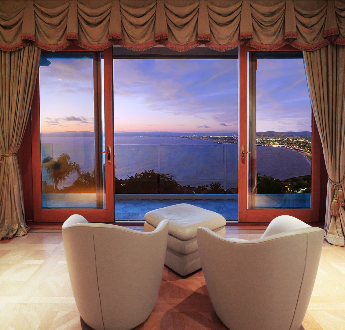 Experience one of the most extraordinary vantage points in Palos Verdes Estates, where an unobstructed 210-degree panorama unfolds across the Pacific Ocean, Queen's Necklace, Santa Monica Bay, Los Angeles skyline, San Gabriel and San Bernardino Mountains, Channel Islands, and Point Mugu. Perched along one of the city's most coveted streets, this exceptional estate offers a front-row seat to Southern California's ever-changing coastal beauty, from brilliant sunsets to sparkling city lights.    Designed to embrace its remarkable setting, the residence features five luxurious ensuite bedrooms, each capturing beautiful views and offering its own private exterior entrance. The grand primary suite is an extraordinary retreat with sweeping ocean vistas, dual walk-in closets, separate his-and-her bathrooms overlooking the coastline, and a private sauna.    The chef's kitchen features a generous center island, beautifully refinished natural wood cabinetry, and an oversized walk-in pantry. Rare quarter-sawn golden oak hardwood floors flow throughout, while expansive French doors invite the outdoors in. Approximately 1,500 square feet of upper and lower terraces, finished in imported Italian porcelain in a classic Versailles pattern, create an exceptional setting for entertaining, dining, or enjoying the endless views.    The resort-inspired grounds feature a sparkling pool with waterfall and spa surrounded by lush, mature landscaping. Meandering terraced gardens offer year-round color and fragrance, while a private orchard produces oranges, lemons, nectarines, peaches, avocados, figs, strawberries, and more.    Ocean breezes drift through the property, the sound of waves provides a soothing backdrop, and scenic hiking and biking trails wind through nearby canyons and creeks. On clear days, whales can occasionally be spotted from the living room or primary suite, while the beach is just a pleasant walk away.    The estate is moments from acclaimed dining, luxury resorts, and world-class golf at Terranea Resort, Trump National Golf Club, and other premier courses. A rare opportunity where panoramic views, lush gardens, privacy, and the natural beauty of the California coast come together in one exceptional estate.    Room dimensions not available. Listing agent and seller make no guarantee on room dimensions or square footage.