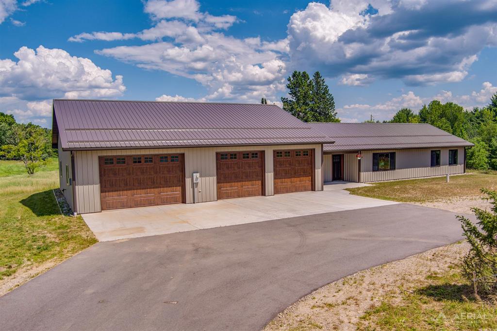 New construction "barndominium" style home sitting on 9.22 acres with circle drive and private pond. This move in ready home has finished concrete floors thru out with in floor radiant heat. Windows are Anderson sliders with auto lock when they are closed. Open living area with vaulted ceiling and overhead lighting. Kitchen has cherry cabinets with pantry cupboard and quartz counter tops ~ lots of space for storage and food prep. Enjoy the adjoining dining and living room plus the great view of the pond. Off the living area is a combo coat closet and laundry room, including front load washer and dryer on pedestals. Spacious guest bedroom has extra space that could be used for office or crafts. Master suite has a large walk in closet, spacious bathroom with tile walk in shower. Both of the bathrooms have handicap toilets and raised vanities with quartz tops. Single French door leads to a large covered patio with beautiful views of this 9+ acre property. Oversized attached 2 car garage (insulated and drywalled) leads to a 26x14 family room/game room with a half bath. Also attached is an insulated 22x40 drive thru garage. This beautiful rolling property has clearings and some mature trees ~ owners previously planted 50 pine seedlings which are close to a foot tall. Deer blind on north side of the property stays and has electric. A must see property semi secluded property not far from West Branch.