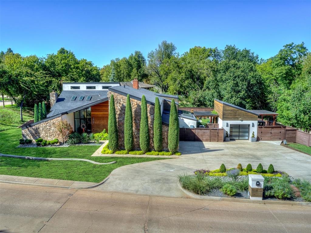 Award-winning home with striking architecture, abundant natural light, and thoughtfully designed spaces define this one-of-a-kind 4-bedroom, 3.5-bath home. Dramatic rooflines, stone and wood accents, soaring ceilings, expansive windows, skylights, and warm wood floors create a distinctive contemporary feel throughout.The main living area features a fireplace and flows seamlessly into additional living and entertaining spaces. At the heart of the home, the spacious kitchen offers an oversized island, double ovens, dual cooking areas, extensive cabinetry, and an adjoining flex space ideal for a butler's pantry, office, or craft studio.The primary suite is a true retreat with vaulted ceilings, a fireplace, private patio access, and a loft perfect for an office, library, or studio. The spa-inspired bath features multiple vanities, a spectacular oversized glass-enclosed wet room with a freestanding soaking tub and dual showers, plus a spacious walk-in closet with an island.Upstairs offers another loft with shuffleboard, media space, two spacious bedrooms with walk-in closets, and a full bath. A large laundry room downstairs provides abundant storage.Outside, enjoy your own private resort with an in-ground pool and elevated spa, multiple patios, covered outdoor kitchen and grilling area, built-in seating, fire pit, and dedicated outdoor dining space surrounded by mature trees and thoughtful landscaping. A 3-car garage plus an additional concrete pad offers space for a golf cart or recreational use.2909 N Oak Hollow Road offers distinctive design, flexible living spaces, incredible entertaining areas, and an indoor-outdoor lifestyle that is anything but ordinary.