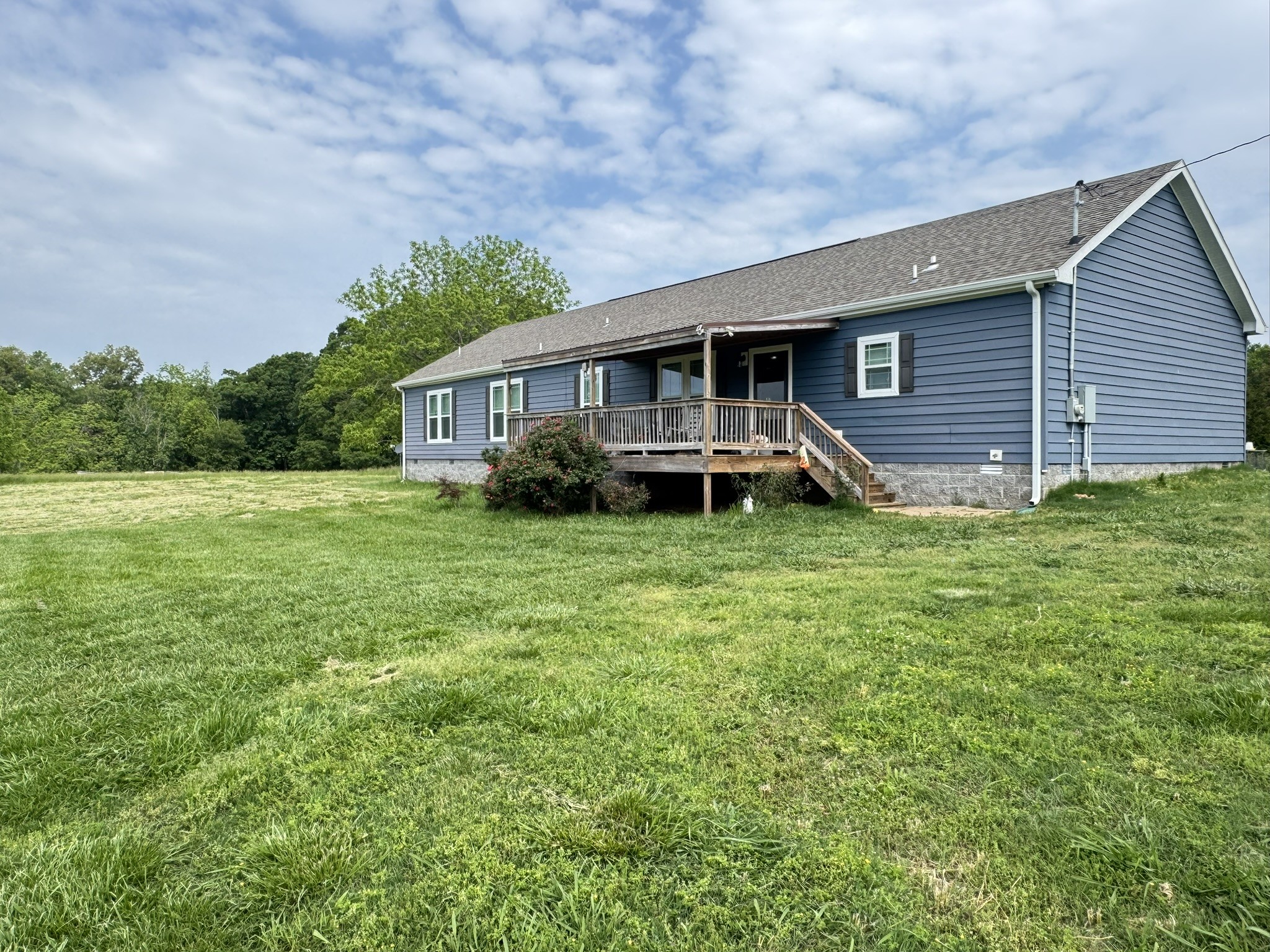 Escape to the tranquility of the Tennessee countryside with this impressive 2500+ square foot modular home set on a sprawling 5-acre lot. The front porch will become your daily get away taking in the breathtaking mountain views. This spacious residence features 4 bedrooms and 3 bathrooms, including a luxurious primary suite with a beautiful walk-in shower and a separate soaking tub – your personal oasis. The addition of an expansive walk-in closet is any fashion maven’s dream! The inviting open floor plan seamlessly connects the living areas, highlighted by a stylish kitchen with a farmhouse sink, a large center island perfect for gatherings, and a high-end Frigidaire Professional built-in refrigerator. Plenty of counter space and cabinet storage make this kitchen perfect for the chef in any family! Enjoy casual meals in the charming eat-in dining room and relax in the expansive secondary living room. Durable tile flooring flows throughout the main living areas. Car enthusiasts or hobbyists will appreciate the large detached 2-bay shop/garage, offering ample space for projects and storage. Embrace country living without sacrificing modern comforts in this exceptional property. Make the call TODAY to see this sweet slice of Tennessee heaven!