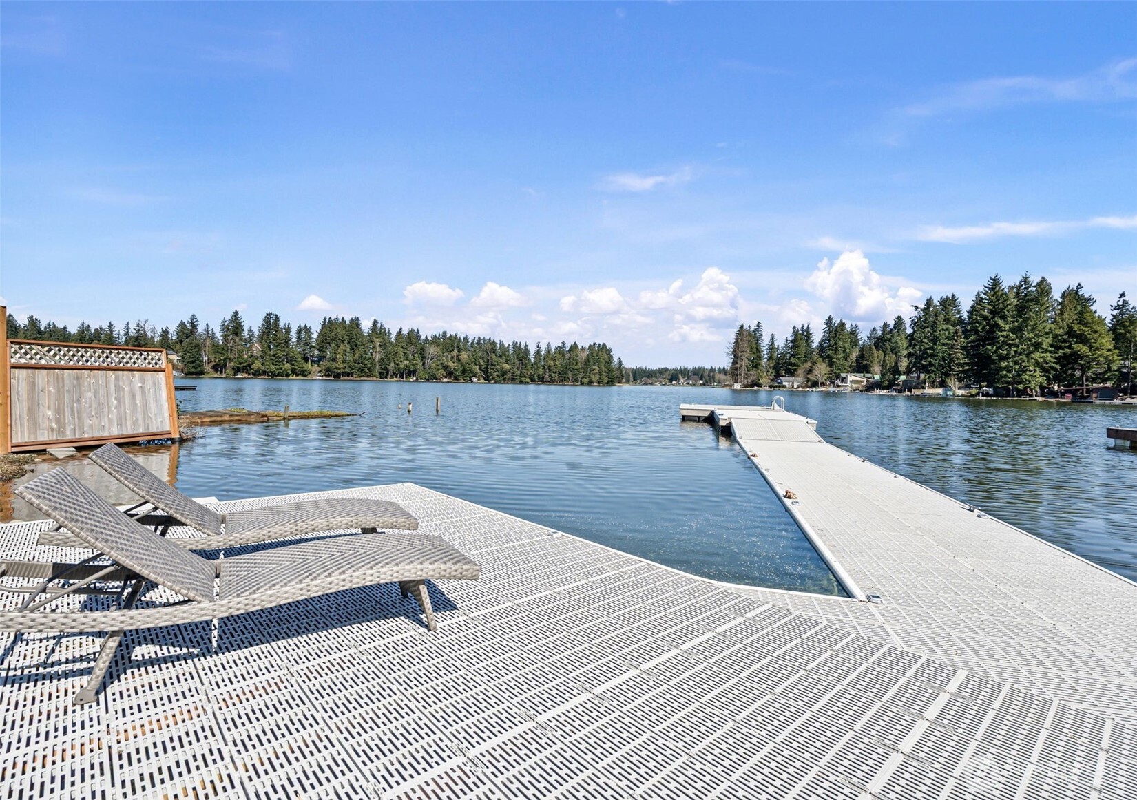 Welcome to your waterfront retreat on Lake Lawrence, just in time for summer fun! Enjoy fully motorized boating, year-round fishing, & all the water sports! Large picture windows line the main living space, bringing in natural light & uninterrupted lake views. A cozy gas fireplace anchors the living area, while French doors lead out to the patio for easy indoor-outdoor living. Just off the entry, a mudroom with laundry hookups adds everyday function. The kitchen has been updated with brand new quartz countertops, stainless steel appliances, & bar seating. A main floor bed & full bath with heated floors completes this level, along with AC for year-round comfort. Upstairs, the primary bedroom with custom built-in storage opens to a private balcony overlooking the lake, as well as an additional bed & bath. Outside, a professionally designed, terraced landscape with new sprinkler system & outdoor lighting carries all the way to the water’s edge, creating multiple areas to gather-from the large patio off the home with a firepit area to the lower-level spaces near the shoreline. A NEW oversized dock completes the setting with approx. 60ft of waterfront & easy access for everyday enjoyment. Set behind a gated entry on a private, fully fenced 1/3-acre lot, the property also offers a 2 car garage, huge driveway, & RV parking. Located just down the road from the public boat launch, this waterfront home is suited for both full-time living or a relaxing weekend escape.