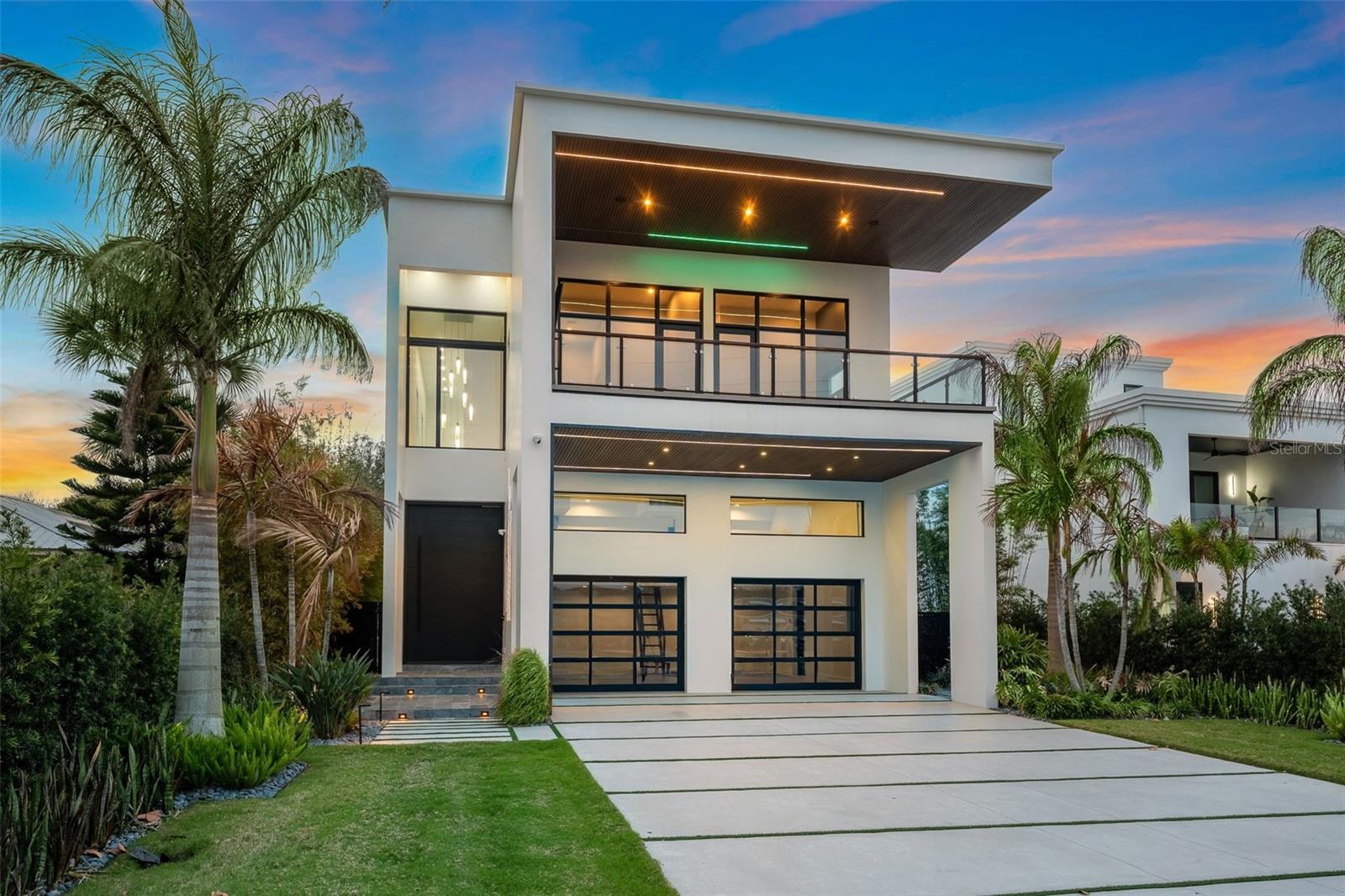 ***EXCEPTIONAL OPPORTUNITY FOLLOWING A SIGNIFICANT PRICE ADJUSTMENT*** Direct Intracoastal luxury waterfront home in New Smyrna Beach, Florida, with deep water access, two blocks from the beach, and partial ocean views. This is coastal living at the highest level. Designed with a modern-inspired style, this new construction home offers a rare opportunity for both intercostal and beach living. 5-bedrooms, 5 full baths, 2 half baths, and over 5,500 square feet of modern design. Featuring clean architectural lines, soaring ceilings, and walls of glass capturing panoramic water views throughout. Situated on 51 feet of deep-water Intracoastal frontage, the property includes a seawall, private dock with water, electric, fish-cleaning station, and a boat slip accommodating a 40-foot yacht, ideal for dock-and-go boating, with future boat lift potential. The outdoor living space offers both relaxation and entertaining, with a fully automated Jandy saltwater infinity-edge pool and spa, tanning shelf, water features, fire elements, and a premium lighting package enhancing the waterfront setting day and night. The expansive waterfront patio and covered lanai create a resort-style environment, complemented by a fully equipped summer kitchen featuring a built-in gas grill, sink, ice maker, storage, and a 42-inch gas range. Inside, the open-concept main level offers seamless indoor-outdoor flow with three access points to the pool deck, connecting interior living spaces to the waterfront. The chef’s kitchen is outfitted with a premium Thermador appliance suite, including a 6-burner gas range with double ovens, refrigerator, wine fridge, freezer, and dishwasher, along with a Sharp microwave, farm sink, waterfall-edge quartz island, and sleek soft-close cabinetry with motorized upper cabinets. The first floor includes a private suite with a full bath and a walk-in closet, a hidden half bath, and laundry room. Additional features include wide-plank oak flooring, oversized baseboards, and a custom staircase with built-in lighting. A private elevator with automatic doors connects all three levels. Upstairs, on the second level you find the primary suite offering a private balcony overlooking the Intracoastal, a spa-style bath with walk-in shower, Hilo sauna, and steam room, along with a custom-built closet with LED lighting. Direct balcony access from both the bedroom and bath enhances the indoor-outdoor connection. The second level also includes a second laundry room and three additional bedrooms with ensuite or adjacent baths, including two with a shared balcony. The third floor features a spacious observatory-style loft designed for entertaining, complete with a wet bar, sink, wine fridge, and half bath. This level opens to both a waterfront balcony and a rear-facing balcony with ocean views, creating a unique elevated entertaining space with panoramic vistas and strong indoor-outdoor flow. Additional highlights include Crestron lighting automation, a two-car garage with high ceilings and epoxy flooring with potential for lifts, and an expansive driveway accommodating multiple vehicles. Positioned between the Intracoastal Waterway and the Atlantic Ocean, the property offers a rare boat-to-beach lifestyle just minutes from Flagler Avenue, top restaurants, marinas, and a 2-minute walk to the beach. New construction Intracoastal homes with deep water, private dockage, modern architecture, and ocean views are rare. This is a standout opportunity!