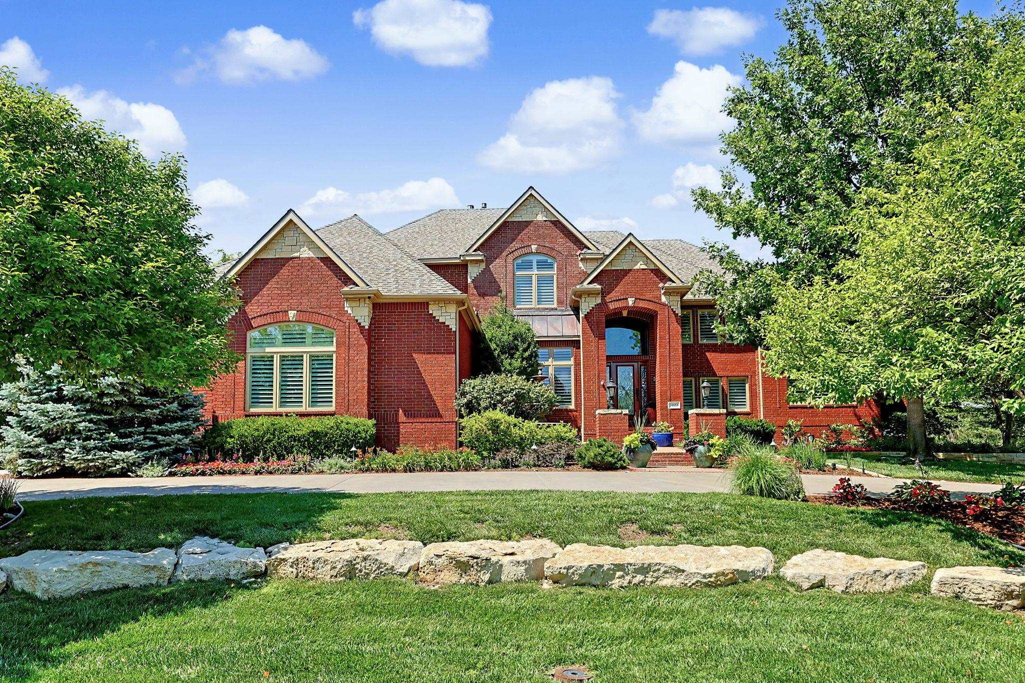 This spectacular full brick 1.5 story estate style home has incredible curb appeal and is located on a meticulously landscaped 1.2-acre lot in the beautiful Savanna neighborhood. Over 6,500 SF finished with 7 bedrooms and a 4-car garage. The impressive main floor features a 2-story foyer, formal living room with 2 way gas fireplace and large windows overlooking the backyard, spacious formal dining room with built-in cabinet, a wonderful gourmet kitchen with 2 islands, an eating bar, an abundance of cabinetry and counter space, huge walk-in pantry, 6 burner gas range with vent hood, a sub-zero refrigerator and a spacious informal dining space. The kitchen opens up to a fantastic hearth room overlooking the backyard and a wonderful sunroom to enjoy your morning coffee. The main floor also features a beautiful office and a luxurious and spacious master suite with a spa-like bath and exceptional closet space. The upper level includes 4 nice size bedrooms each connecting to Jack and Jill baths. The walkout basement is the perfect place to relax and have fun with your family. A large family room and game room area, very large bar area, 2 more bedrooms, another full bath, an exercise room, a concrete storm shelter and several spacious storage areas. The gorgeous, fenced backyard is lined with mature trees and features a beautiful 20’x40’ pool and plenty of seating areas on the patio and deck. Just a short golf cart ride from Crestview Country Club, an easy walk to the Redbud Trail, 5 minutes to most of east Wichita’s premier dining and shopping areas and lest than 10 minutes to the areas best public and private schools.