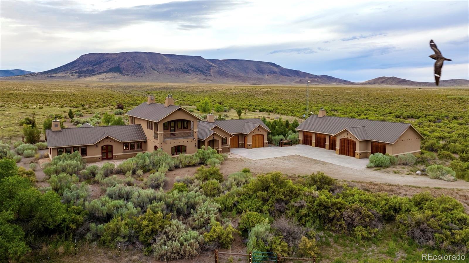 Perched on 137 Acres with over 3/4 of a Mile of frontage along both sides of the Rio Grande River, this immaculate Custom Home is an amazing place to continue Your Family's Legacy — whether you’re raising a Family, embracing Retirement, or chasing Rocky Mountain Dreams. Built in 2012, the Custom Home offers 3,888 square feet of living space with 3 Bedrooms and 2 Full Bathrooms and 1 Half Bathroom. The Home is thoughtfully designed to capture the Breathtaking Views of the Rocky Mountains that surround the Property. All the modern amenities were incorporated into the Home along with High-End Appliances, ample Storage and even an electrically powered Dumb Waiter that convenietnly connects All Floors, including the Basement. Attention to detail and high-end finishes include the Cherry Wood Trim throughout the Home, Custom Cabinets, Built-In Shelving and Desks. Each closet is lined completely in Cherry Wood. Adding to the Spanish inspired style of the Home, all of the Doors and Doorways throughout Rounded, providing a more harmonic energetic feel as you travel from room-to-room.  Attached to the Main Home is a 2 Car Garage with Heated Floors. The 864 square foot Basement houses the mechanical systems of the Home and offers additional space for storage and the opportunity to finish the basement for additional living space. There is a sophisticated Security System with motion sensors and alarm notification when doors are ajar, enabling you to watch over the Home from anywhere. There is also a 1,488 square foot Custom 5 Bay Garage / Workshop that is Insulated and Heated. This amazing flexible space is detached from the Main Home, but conveniently remains only steps away. This additional structure was designed to blend seemlessly with the the style of the Main Home, complete with wooden garage doors.