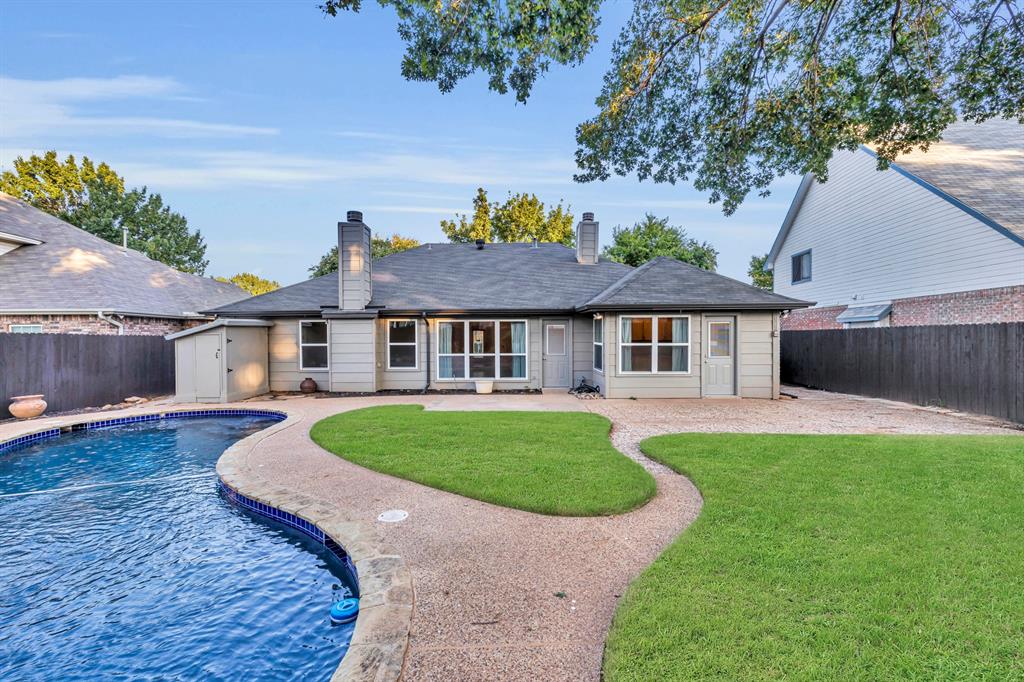 Ready to cool off in your own pool?  This charming single story home with a pool and plenty of play space has been lovingly maintained.  Nestled on a beautifully landscaped lot, the home boasts a charming brick porch, mature trees, flower beds, lush front and backyards, a stained privacy fence, flagstone pathways, plenty of deck areas in backyard, and a storage shed.  Inside, you're welcomed by a raised entryway with coat closet, soaring tray and vaulted ceilings in the great room, rich wood floors, designer light fixtures, updated hardware, and fresh, neutral paint throughout. Energy-efficient Low-E vinyl windows were installed less than five years ago to keep things cool and quiet.  The spacious eat-in kitchen features an abundance of maple cabinetry, a stylish mosaic backsplash, stainless steel appliances (including gas range, dishwasher, and refrigerator), and a sunny greenhouse window perfect for growing fresh herbs. Two cozy gas fireplaces, one in the living room and another in the private primary suite, create the perfect ambiance. The split-bedroom floor plan offers privacy, and the oversized primary retreat includes a sitting nook, dual vanities, jetted soaking tub, separate shower, maple cabinetry, and a private water closet. Other highlights include a full-size laundry room with shelving, an insulated 2-car garage with built-in workbench and storage, ceiling fans throughout (even in the kitchen), and thoughtful touches like window seats, medicine cabinets, and generous closet space. All of this in a prime location zoned to top-rated GCISD schools (OC Taylor, Colleyville Middle, Heritage High). Just blocks from Pecan Park and minutes to Parr Park, historic Downtown Grapevine, Southlake Town Square, DFW Airport, and major highways.