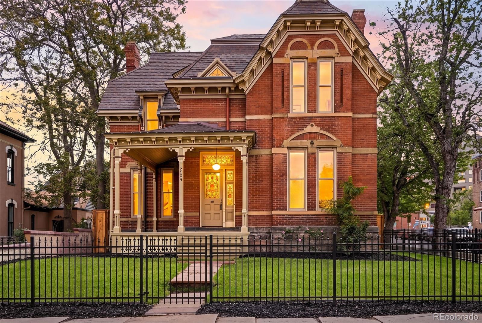 A rare opportunity to own a restored piece of Denver history - welcome to the iconic H.H. Thomas House, designed by noted architect William Quayle and proudly listed on the National Register of Historic Places. Once home to renowned CO photographer Louis C. McClure, this residence carries a rich artistic legacy. Thoughtfully restored throughout, the home seamlessly blends timeless craftsmanship with modern comfort. A Victorian secret garden oasis right in the city. Step inside and feel the story unfold - soaring 12’ ceilings, a stunning custom mahogany staircase, and four original wood-burning fireplaces anchor the home in its rich past. You are greeted by original stained glass doors, intricate brass hardware, gorgeously refinished Quarter Sawn Oak hardwood floors, and original Edison-Patent chandeliers. The beautifully updated kitchen features new cabinetry, quartz countertops, chef-grade appliances, and abundant storage. The main floor bathroom is a showpiece with hand-painted Scalamandre William Morris wallpaper and a classic pull-chain toilet. Upstairs you'll find original Great Heart Pine hardwood floors throughout. The primary suite features a spacious walk-in closet and an updated bathroom with full tile, a built-in cast iron tub, new cabinetry, and refinished brass hardware. Two additional bedrooms are equally charming and filled with natural light. Major system upgrades provide peace of mind, including new HVAC with furnace and A/C, new hot water heater, and updated plumbing - all thoughtfully completed with future basement finishing in mind. Step outside to a newly landscaped yard, fully enclosed by a brand new fence and filled with mature greenery and garden spaces. A detached two-car garage features new low-profile overhead doors, complemented by a brand new concrete driveway. All just steps from Denver’s best dining and everyday amenities. This is more than a home, it’s a preserved piece of Denver’s architectural legacy ready for its next chapter.