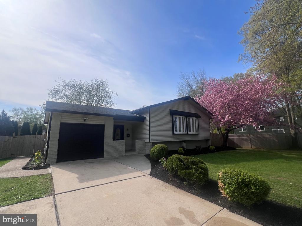 Location, location, location—welcome to 122 Oxford Place, a beautifully renovated and meticulously maintained home set on a generous .22-acre lot on a quiet street in the desirable Canterbury neighborhood of Mount Laurel, offering over 3,000 square feet of thoughtfully designed living space across three expansive levels, complete with five spacious bedrooms, three full bathrooms, and exceptional indoor and outdoor entertaining areas; from the moment you arrive, you’re greeted by impeccable curb appeal featuring manicured landscaping and vibrant cherry blossom trees that frame the home with color and charm, while inside, a freshly painted interior in elegant Graceful Gray welcomes you through a grand foyer with stylish tile flooring, a modern gold chandelier, and a convenient coat closet, leading up a striking black-and-white staircase into a bright and inviting living room with recessed lighting and gleaming espresso hardwood floors that flow seamlessly throughout the main level, complemented by a formal dining room adorned with a designer chandelier and an oversized five-stool quartz breakfast bar that opens to a magazine-worthy kitchen showcasing sleek quartz countertops, a chic backsplash, stainless steel appliances including a KitchenAid refrigerator, gold hardware, a large light gray pantry cabinet, recessed lighting, and sliding doors that provide easy access to the expansive wraparound deck—perfect for entertaining; down the hall, the luxurious primary suite offers a truly impressive 13’ x 12’ custom walk-in closet along with two additional closets, ensuite bath with double vanity and a glass-enclosed tile shower, elegant gold fixtures, and direct deck access, while an additional bedroom, full bath with tub/shower, and linen closet complete this level; the lower level features a tremendous family room highlighted by a white brick fireplace wall, black fireplace, and included large flat-screen TV, creating the perfect gathering space, along with three additional bedrooms with ample closets and modern lighting, an upgraded full bathroom with a stand-up shower, and a well-equipped laundry room with GE Profile washer and dryer, extra refrigerator, storage closets, and utility space; adding even more versatility is the impressive 350-square-foot temperature-controlled four seasons room with wall-to-wall windows, skylights, ceiling fan, and included 70-inch flat-screen TV, offering multiple access points to the backyard and garage; outside, the fully fenced and beautifully landscaped yard is designed for enjoyment, featuring a substantial wraparound deck with three points of entry, gated side access, and plenty of space for gatherings, while the oversized one-car garage boasts fresh finishes, upgraded lighting, a 200-amp electrical panel (2023), and a Tesla charging station, with additional driveway parking for three vehicles; recent updates include a newer roof (4 years), hot water heater (3 years), and recently serviced HVAC system, all ideally located within an award-winning school district and offering convenient access to nearby shopping, dining, parks, major roadways including Route 295 and the NJ Turnpike, as well as easy commuting to Philadelphia and the New Jersey shore—this exceptional property blends style, space, and location into the perfect place to call home.