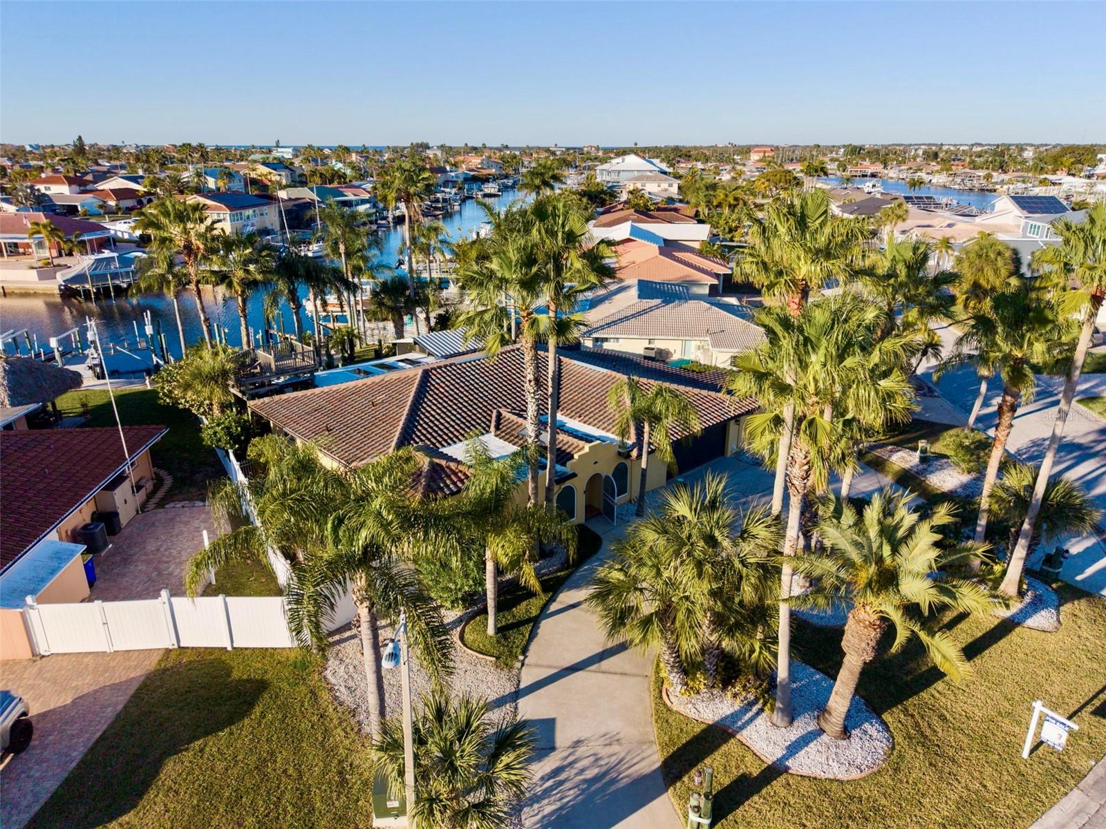 One or more photo(s) has been virtually staged. JUST REDUCED! Ultimate Deepwater Mariner’s Compound – Massive Value Opportunity!Stop chasing marine contractors and start cruising. Why wait years for permits and face skyrocketing marine construction costs when you can move right into a finished, bridge-free, deepwater compound today? This property represents unparalleled infrastructure equity. Positioned for the serious mariner, the premier waterfront setup includes a dedicated 50’ yacht slip, a secondary 27’ boat slip, a heavy-duty davit, a kayak lift, and a rock-solid concrete seawall. Enjoy a short, bridge-free ride to the open Gulf and world-class barrier island beaches, providing immediate access to the offshore tournament fishing or cruising lifestyle you’ve been waiting for.The outdoor experience is anchored by an expansive deck with unobstructed views of Florida sunsets and local marine life, from dolphin and manatee to tarpon and snook. With an oversized 10,454 sq. ft. corner lot, there is significant space to customize your dream pool/outdoor kitchen oasis. Inside, the 2,491 sq. ft. open-concept floor plan features a theater-style living room, spacious family room, and chef-inspired kitchen with solid wood cabinetry and quartz countertops. The layout includes three expansive bedrooms and four bathrooms, with the garage-level utility space currently housing laundry, a configuration offering a prime opportunity to tailor the space to your specific needs.High-value mechanical upgrades provide peace of mind, including an oversized garage, full RV hook-ups, and generator connections with a safe transfer interlock. We include a 12KVA Dual Fuel Portable Generator with cables to ensure you are always ready for the season. Residents also enjoy community access to a private beach (separate membership required) and proximity to the developing Gulf Harbors Park.This is more than a home; it is a meticulously equipped asset for the big-boat enthusiast. Priced to account for your personal vision, this property offers an aggressive value proposition that is light-years ahead of the competition. Come see it today and stop living with "someday" plans!