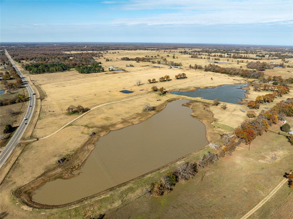 Highway 82 Ranch is a 192 acre turnkey working ranch situated 4 miles east of the town of Blossom, TX.  This turnkey operation includes 2 sets of covered working pens, hay barn, equipment shed, multiple pens, two lakes, pivot irrigation and a residence on site. The covered pens come complete with concrete floors, alley, and semi load out. Two lakes border the east boundary offering 16 total acres of water for 945 ft of Reinke pivot irrigation over improved bermuda grass for hay production or grazing. The hay barn features wooden floors and heated and cooled storage rooms. The ranch is fenced and cross fenced with water in each pasture, and multiple pens with water troughs in each. Gravel roads throughout the ranch provide easy access in any type of weather.  A manufactured home on site for owner or ranch hand quarters. Highway 82 Ranch is an incredible opportunity to own one of the most productive ranches Lamar county has to offer. Call to schedule your private showing today.