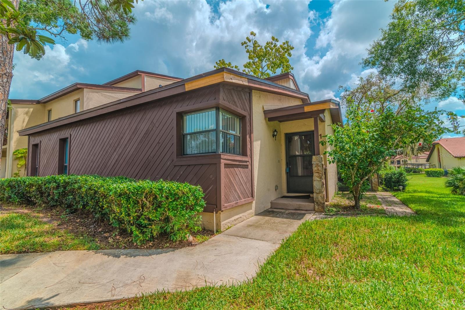 Welcome to this immaculate end unit that feels larger than life! Located in the Tarpon Woods corridor, this 2 bed 2 bath offers 1335 sq ft but feels much larger with its open concept and sizeable bedrooms. The location allows for grassy knoll views and extra privacy from the adjacent units. Stepping inside the unit you will find a great room plan. The kitchen has wood cabinets and a large breakfast nook counter (great for food prep) and is open to the rest of the living area for access to your guests while you are entertaining. Just off the kitchen is a full laundry room. The living/dining room has two sliders that open to the oversized, covered, screened in wrap around porch. The primary bedroom offers two closets and a slider that goes out to its own private covered, screened in porch. The primary ensuite has been partially updated and upgraded with wooden vanity, dual sinks, granite counter, mirror, and lighting. The second bedroom is of ample size and has a walk-in closet. The secondary bath has also been partially updated with wooden vanity, granite counter, mirror, and lighting. The A/C was replaced in 2019. Just across the way is scenic John Chestnut Park which is waterfront to beautiful Lake Tarpon. Golfers can take advantage of proximity to Lansbrook GC, Tarpon Woods GC and East Lake Woodlands Country Club. The affordable monthly dues cover water, sewer, trash, exterior maintenance, and a large community pool. Schedule your private tour of this lovely unit today!