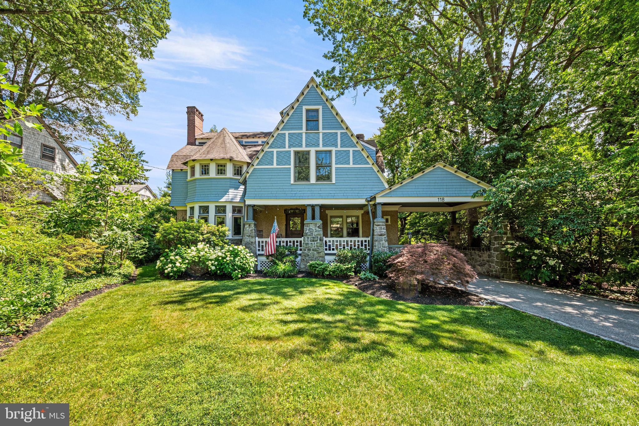 Designed by noted Philadelphia architect William L. Price as one of his celebrated “Pillar Houses” for the brand-new Wayne neighborhood and completed in 1890, 118 Walnut Avenue is a remarkable example of Victorian craftsmanship and architectural detail. Intricately carved woodwork that has never been painted, Victorian tile, oak hardwood floors, etched glass windows, and countless preserved period features can be found throughout this extraordinary residence.Created for both comfortable daily living and entertaining, this 6-bedroom, 3.5-bath home is set along a quiet, tree-lined street just blocks from the shops, restaurants, and amenities of downtown Wayne. Stone pillars mark the entrance to the driveway, which extends beneath an original covered porte cochère to the detached two-car garage. The home's impressive front porch showcases beautifully carved columns and leads to a welcoming foyer with parquet floors and a stained-glass window.At the center of the home, a center hall features a carved staircase and built-in bench. Through a set of pocket doors, the library/den offers a corner fireplace with its original tile surround, mantel, and mirror. A hidden powder room tucked behind custom millwork and glass-front built-in cabinetry are among the room’s many distinctive details. Nearby, a spacious living room with gas fireplace and charming window seat overlooks the front gardens.The kitchen combines historic character with thoughtful updates, featuring a leather-finished soapstone island with seating and a double sink, original built-in cabinetry with a beverage refrigerator, a sunny breakfast area, and access to the rear deck. A generously sized walk-in pantry provides additional storage options.The formal dining room is well suited for gatherings both large and small, highlighted by original corner cabinets, a fireplace with its original mantel and mirror, and a bay of windows that fills the room with natural light.Heading up to the second floor, the recreation room once housed the home's original pipe organ and has been transformed into an inviting space for games, hobbies, or relaxing with family and friends. The primary suite is exceptionally spacious and filled with natural light, offering a decorative fireplace with original tile, dual closet space, and access to a large bath with a soaking tub and separate walk-in shower. A laundry room with additional storage is conveniently located off the hall. Three additional bedrooms occupy this level, including a private bedroom suite with a fireplace and full bath featuring antique marble sinks.The third floor provides two more bedrooms, a new full hall bath with a walk-in shower, and several storage areas.Outside, the rear yard boasts mature trees and established perennial plantings surrounding a firepit seating area bordered by one of the property's original stone walls. The detached two-car garage, converted from the original carriage house, retains its historic character and includes a second level for storage complete with a Dutch barn door.A rare opportunity to own one of Wayne’s architectural treasures, this exceptional home offers easy access to downtown Wayne, the Wayne train station, Route 476, and other major commuting routes, all within the award-winning Radnor school district.