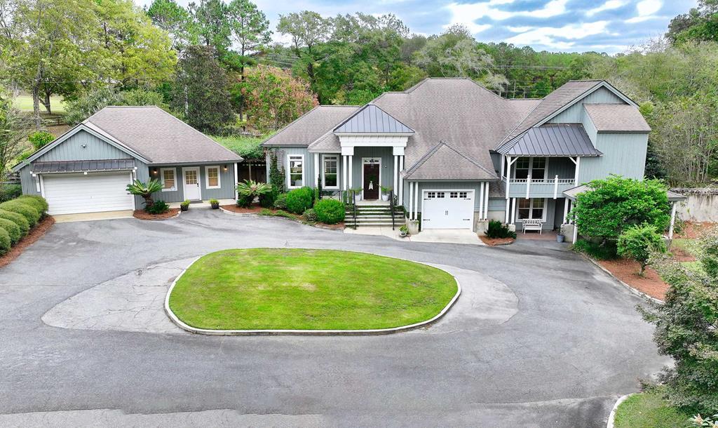 A custom-built home that perfectly blends luxury, craftsmanship, and country living. Situated on 22.56 acres just minutes from town, this property offers the peace and privacy of rural life with all the conveniences nearby. From the moment you step inside, you'll feel the “WOW” factor. This stunning home features 3 bedrooms, 2 full bathrooms, and 1 half bathroom, plus an additional room that can serve as a fourth bedroom, home gym, or office. The spacious living room is a showpiece, with soaring coffered ceilings, heart pine cabinetry, and a built-in bar with a marble countertop and wine cooler. Custom doors and fine finishes are found throughout, showcasing the attention to detail that makes this home truly one of a kind. The kitchen is designed for both style and function, offering abundant cabinetry, granite countertops, and a gas cooktop—perfect for the home chef. The large master suite is a private retreat, featuring a cozy sitting area, gas fireplace, and a loft space ideal for reading or a creative studio. The master bathroom feels like a luxury spa with split vanities, custom cabinetry, a soaking tub set in a teak and copper base, and a beautifully tiled walk-in shower. Additional highlights include a six-zone HVAC system for year-round comfort and a charming side cottage that offers endless possibilities—whether you need a home office, man cave, guest space, or extra storage. The cottage also includes its own garage and a breezeway connecting it to the main home. Step outside to your own backyard oasis featuring a sparkling saltwater pool with a waterfall, surrounded by picturesque views of the property. Large windows throughout the home fill every room with natural light and allow you to take in the beauty of the surrounding landscape. If you've been searching for a custom home on acreage close to town, this is the one you've been waiting for. Schedule your personal tour today and experience all that this exceptional property has to offer.