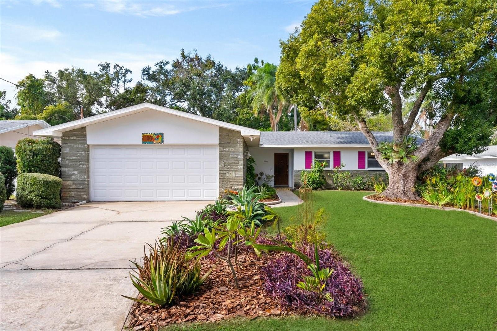 A whimsical mid-century escape in the heart of Dunedin! Adjacent to the peaceful trails of Hammock Park, this mid-century modern treasure feels like something out of a storybook. With over 1500SF of sunshine-filled living space, this 2 bedroom, 2 bath retreat blends artistic charm with everyday comfort.  Inside you will find open airy rooms with luxury vinyl flooring, two updated bathrooms, and a spacious eat in kitchen that just begs for morning coffee and easy Sunday breakfasts. The wood burning fireplace in the family room adds a cozy glow on cooler nights, while the huge picture window in the living room perfectly frames the sparkling pool and leafy views beyond.  Step outside and feel the magic of a shimmering pool, two expansive wood decks, and brick pavers that set the scene for sunny afternoons and laid-back evenings with friends. The fully fenced yard means your furry companions can roam freely in "Dogedin", one of Florida's most pet-loving towns.  Practical comforts are all here too: New roof (2024), Electric water heater (2019), Central AC (2017), Hurricane shutters, Upgraded ceiling fans throughout and the peace of mind that comes with being outside the flood zone and untouched by storms.  Best of all, you are just a short stroll from the Dunedin Fine Art Center, the Pinellas Trail and all the creative energy that makes this little coastal town so special.  This is more than a home...it is a vibe.  A place where art, nature and good company come together under the palms.