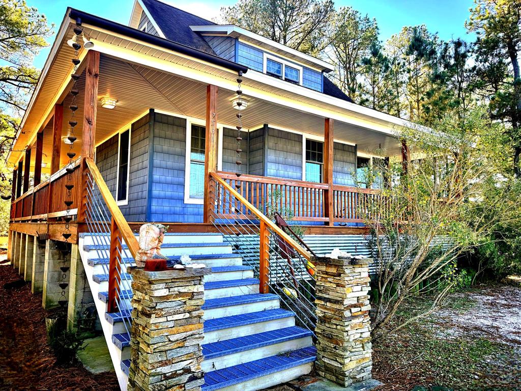 TURN KEY & FULLY FURNISHED. Beautiful custom coastal cottage tucked along a quiet canal with Chincoteague Bay views. Enjoy abundant wildlife from the large screened porch and multiple outdoor living spaces. Features include Australian Cypress floors, industrial accents, granite kitchen, and a private second-floor suite with loft and whirlpool tub. Quality construction with 2x6 walls, Andersen windows/doors, and cedar-impression siding. With 820 sq. ft. of porches, a patio, fire pit, outdoor shower, and waterfront deck nestled in the pines, this charming retreat offers the perfect Chincoteague getaway.