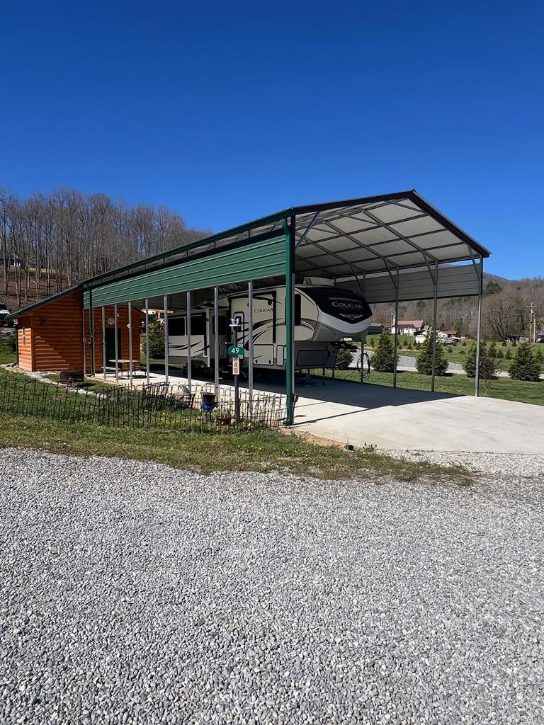 Looking for the perfect mountain getaway for your RV? Welcome to Stecoah Valley RV Resort! This well-appointed lot features a concrete RV pad, impressive 24x50 RV carport, & a 12x16 utility building complete w/ bunkhouse, loft, washer & dryer, & a full bathroom w/ step-in shower—everything you need for comfortable extended stays for all your friends and family!  As an added bonus, a 2021 Cougar 32' fifth wheel w/ two bedrooms & three slide-outs is included, making this a true turnkey setup.  Ownership in this sought-after community includes water & sewer, lawn maintenance, road upkeep, & access to two covered common areas—one nestled beside a peaceful mountain branch—all for just $550 per year.  This is not a rented lot, it is deeded ownership & sits on a flat 0.11 acre lot w/ a buffer between the lots. Enjoy year-round easy access in the scenic Stecoah Valley, just 25 minutes from Bryson City & minutes from some of the region's top outdoor destinations, including Tsali Recreation Area, Fontana & Santeetlah Lakes, Nantahala Outdoor Center, Tail of the Dragon, Cherohala Skyway & Harrah's Cherokee Casino. Are you ready to start enjoying RV life? If so, this one checks all the boxes!