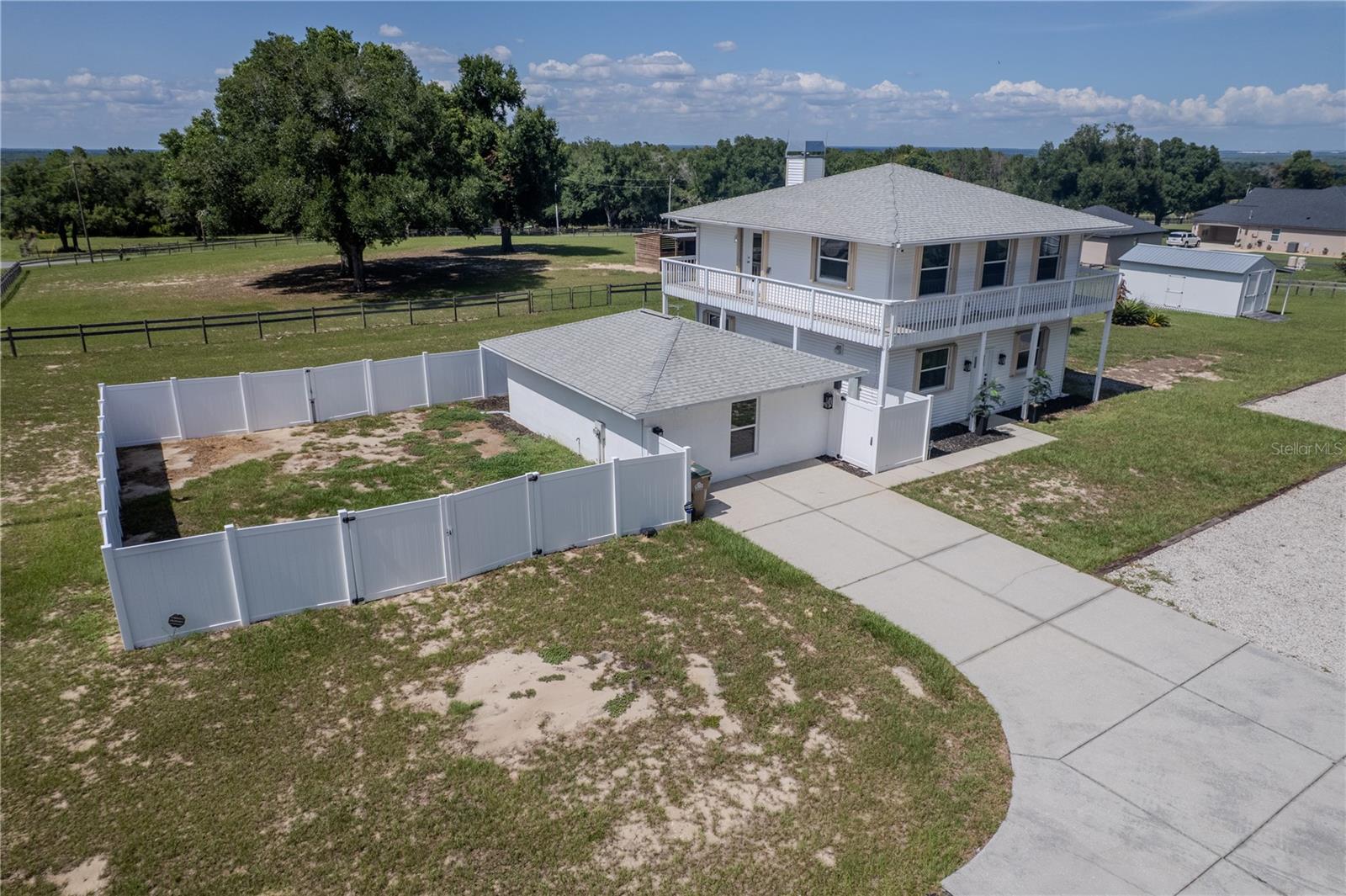 Perched on 5 FULLY FENCED ACRES in the highly sought-after Sugarloaf Highlands community, this extraordinary estate offers a rare combination of LUXURY RENOVATIONS, a massive custom workshop, equestrian amenities, and exceptional FLEXIBILITY. Nestled within the rolling hills of the Sugarloaf Mountain region—one of Florida's highest elevations—this unique property provides the PRIVACY, FREEDOM, and SPACE that are becoming increasingly difficult to find.Originally custom-built and extensively renovated, the home has been transformed into a bright, OPEN-CONCEPT RETREAT designed for both everyday living and entertaining. Public records reflect a 3-bedroom, 2-bath home. The current owners reimagined the upper level into an EXPANSIVE OWNER'S RETREAT, creating a spacious and flexible layout while preserving the home's unique character.At the heart of the home is an OVERSIZED GRANITE ISLAND that anchors the gathering space and flows seamlessly into the chef-inspired kitchen featuring premium KITCHENAID STAINLESS STEEL APPLIANCES, a handcrafted COPPER FARMHOUSE SINK, and abundant workspace. The spacious living area is highlighted by a WOOD-BURNING STOVE with INTEGRATED COOKTOP, while windows and abundant natural light create a bright and inviting atmosphere throughout.Occupying the entire upper level, the private owner's retreat serves as a peaceful sanctuary complete with WRAPAROUND BALCONY access overlooking the surrounding countryside and distant lake views. The elevated location provides beautiful sunset views and refreshing year-round breezes. The spa-inspired primary bath features a custom OVERSIZED SHOWER with DUAL SHOWER SYSTEMS, BODY SPRAY JETS, DUAL VANITIES, and elegant finishes. The guest bath offers a handcrafted COPPER SINK and relaxing SPA SOAKING TUB.The property is equipped to support a wide variety of lifestyles and allows vehicles, trailers, and equipment to access virtually every area of the acreage with ease. Horse enthusiasts will appreciate the FENCED PASTURES, mature SHADE TREES, and custom-built HORSE STABLE with enclosed TACK ROOM. One of the property's most impressive features is the OVERSIZED CUSTOM-ENGINEERED METAL GARAGE and workshop. Designed with high-clearance ceilings, electrical service, and abundant storage capacity, the structure easily accommodates boats, trailers, heavy equipment, car collections, workshops, and more. RV owners will also appreciate the existing RV HOOKUP with electric, water, and septic connections already in place.Adding even more versatility, a detached AIR-CONDITIONED STUDIO/FLEX BUILDING offers ideal space for a home office, creative studio, hobby room, guest accommodations, or future in-law suite. Additional improvements include DUAL 220-VOLT ELECTRICAL HOOKUPS,  whole-house surge protection, lightning protection systems, STORM SHUTTERS, GENERATOR-READY PROPANE INFRASTRUCTURE, a COMMERCIAL-GRADE WELL SYSTEM, SECURITY SYSTEM, and a CUSTOM ELECTRIC GATED ENTRANCE.Conveniently located near shopping, dining, medical facilities, major roadways, and the SCENIC GREEN MOUNTAIN AREA, this exceptional property offers the perfect balance of peaceful country living and modern convenience. Whether you're seeking a luxury country estate, equestrian property, mini-farm, workshop enthusiast's dream, or simply room to live life on your own terms, this remarkable property delivers a lifestyle UNLIKE ANYTHING ELSE CURRENTLY AVAILABLE.