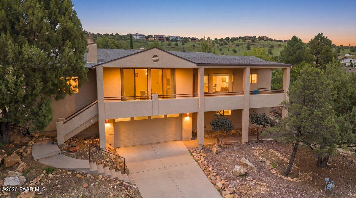 Nestled among mature trees yet conveniently close to major shopping, this inviting home offers the perfect blend of peaceful surroundings and everyday convenience. Vaulted ceilings create an open, spacious feel, while expansive glass door lead to the deck and showcase beautiful views beyond. Cozy up on chilly winter evenings by the fireplace, and step outside on warm summer days to enjoy plenty of  outdoor living space on both the front deck and newly expanded back deck...and this home has one of the largest lots, so no shortage of space to garden or bird watch.The thoughtfully designed split floor plan provides privacy with spacious bedrooms and a bright, airy kitchen that makes living and entertaining a pleasure.Downstairs, you'll find a two-car garage, enclosed ample storage and a separate workout room featuring reversible flooring, allowing you to choose between a cushioned surface or a durable hard surface, depending on your needs. This home offers a wonderful combination of comfort, functionality and beautiful indoor-outdoor living.