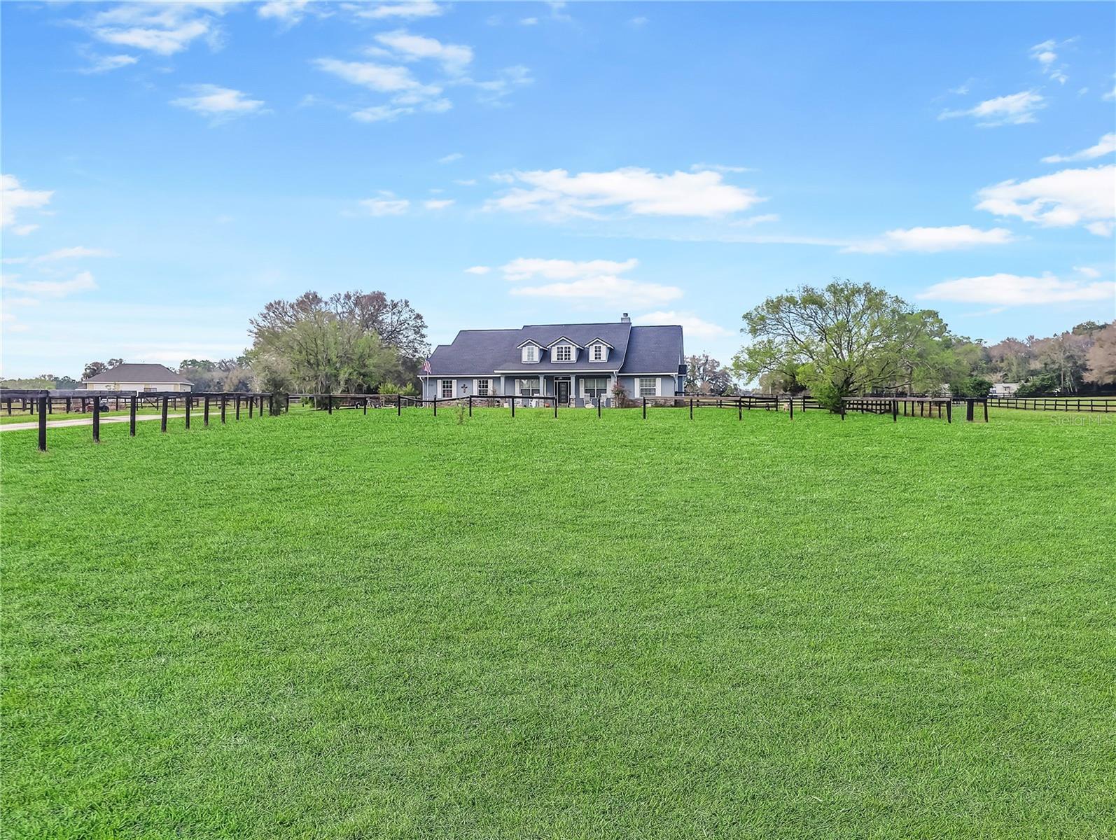 Stunning Custom-Built Home in Cross Tie Ranches – NE Ocala, FL Nestled in the picturesque Cross Tie Ranches subdivision of NE Ocala, this beautifully designed 4-bedroom, 3-bathroom home with a den offers 2,619 sq. ft. of living space on 4.29 acres, perfect for those seeking a blend of luxury and equestrian living. This well maintained property features four paddocks, ideal for horse enthusiasts, and is just 15 miles from the renowned World Equestrian Center. Inside, you’ll find high vaulted ceilings, a cozy wood-burning fireplace, hardwood, upgraded laminate and tile flooring throughout the home and a thoughtfully updated split-bedroom floor plan. The 4th bedroom and 3rd bath can serve as a private in-law suite, offering additional flexibility and privacy. The heart of the home is the kitchen and breakfast nook which overlooks a large and open main living area as well as the large screened lanai that runs almost the entire length of the back of the home. French doors lead to the Primary Bedroom Suite, which boasts a sitting area, lanai access, a walk-in closet, and a spacious primary bath complete with a walk-in shower with dual showerheads and a jacuzzi tub for ultimate relaxation. A large side entry garage offers lots of storage space. A separate side from outside or enter through the garage into the inside laundry / mud room so you can clean off before entering the main living area of the home. Recent upgrades include a new roof (2023), new AC (2022), and a kitchen renovation (2021) complete with elegant granite countertops. Flooring throughout the home consists of hardwood, upgraded vinyl plank installed in the living, dining, entryway and office in 2025, and tile, ensuring both beauty and durability. Experience the perfect blend of modern upgrades, timeless charm, and peaceful country living—all within easy reach of Ocala’s equestrian and outdoor lifestyle.