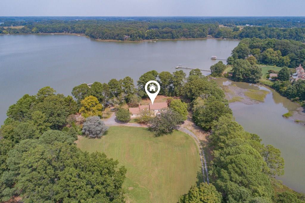 PRIVATE UNIQUE WATERFRONT PROPERTY ESTATE What's special: DEEP WATER ACCESS TO THE CHESAPEAKE BAY, 250FT PIER, BOAT LIFT, SECLUDED ACREAGE Secluded waterfront property ideal for boating, fishing, crabbing, hunting, horses, farming and relaxation, 100.69 acres on the Eastern Shore of VA with deep water access to the Chesapeake Bay, a 250 foot pier with boatlift. 1649 feet of shoreline. Two deer stands. Architectural features 1960s home with 4 bedrooms, 3.5 baths, 1st floor bedroom w/full bath.  Spacious kitchen and a formal living room with fireplace flow into the sunroom with captivating views of the water. Family room with fireplace. Walking/riding trails, Property is in an AFD (choice to end 2026).  30 minutes to Cape Charles Beach, 1 hour to Norfolk International Airport